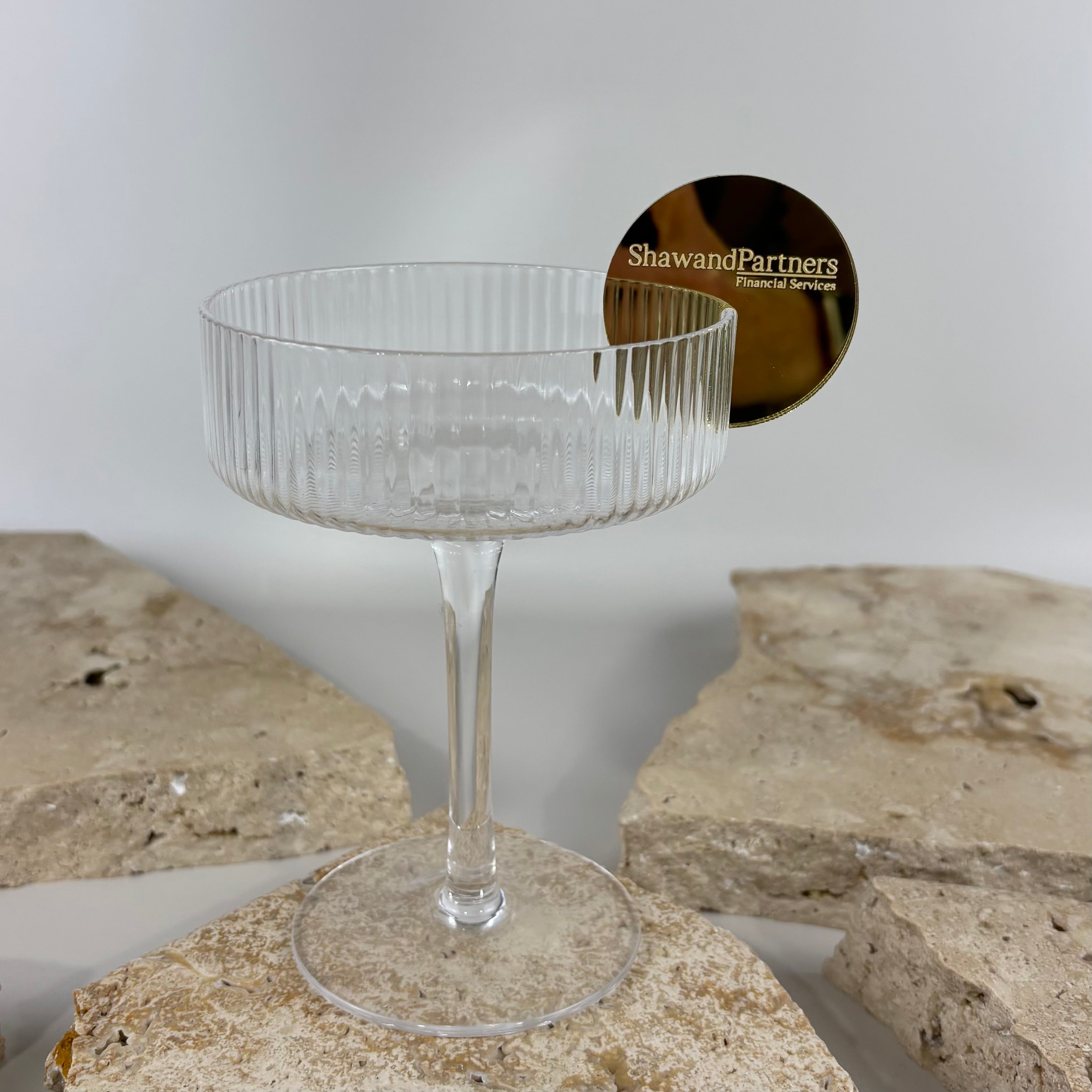 Custom acrylic drink stirrer tag with engraved business logo attached to coupe cocktail glass, personalised event branding accessory for weddings, corporate events, financial services and luxury business functions in Australia.