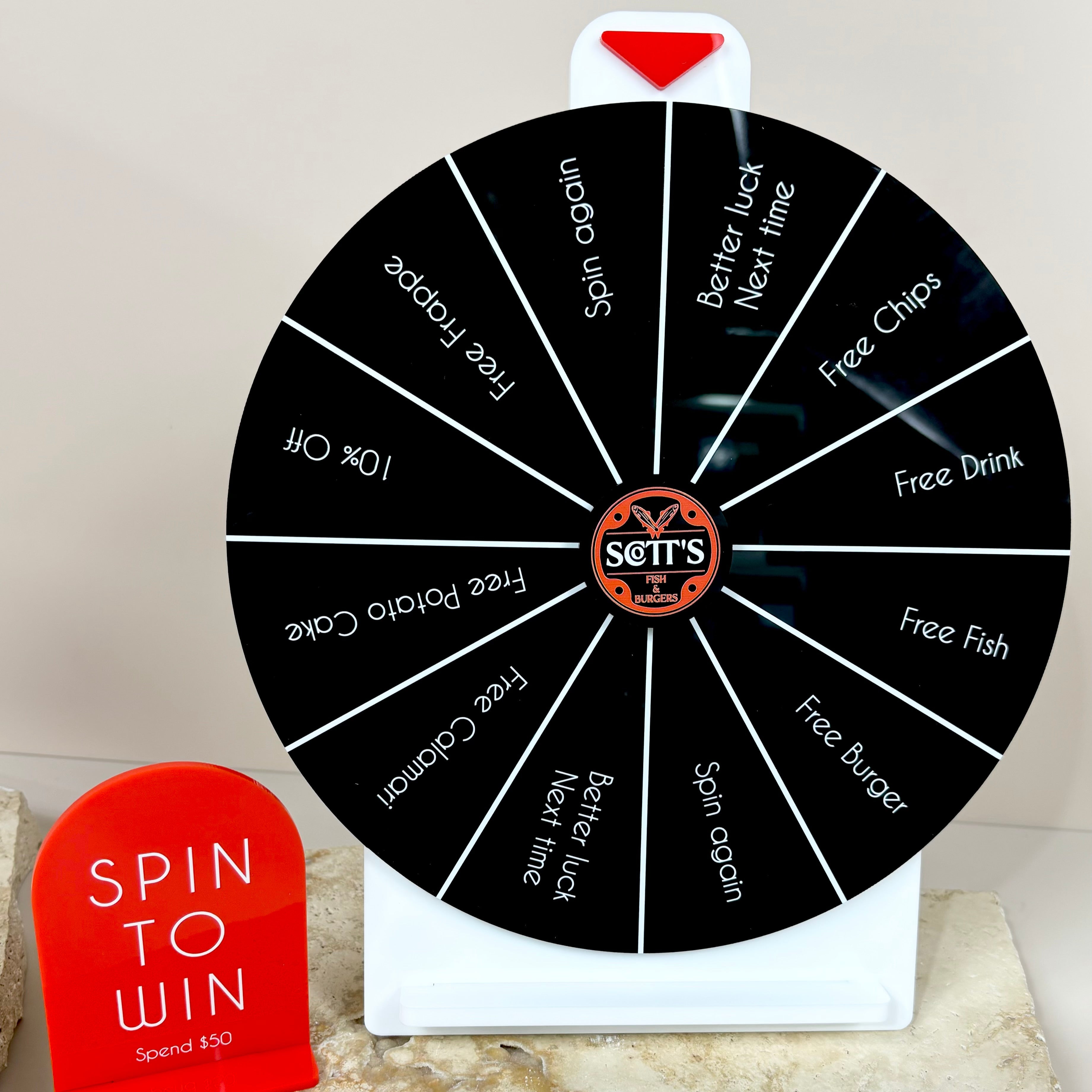 Black prize wheel with bright red spin to win sign for shopfront displays