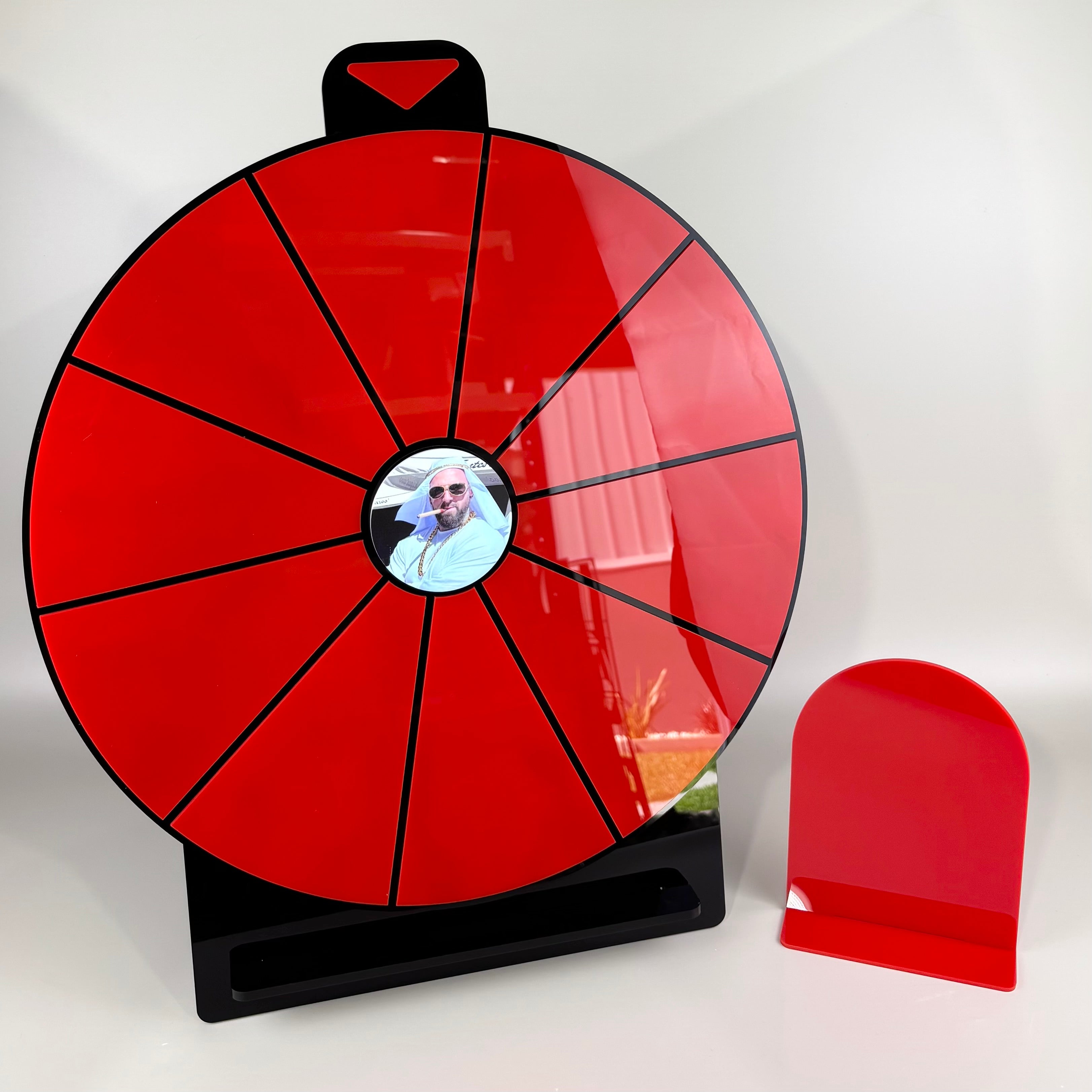 Custom red and black acrylic spin the wheel prize display with blank segments for personalised rewards, featuring a photo centre insert and matching red counter sign, designed for business promotions, events and giveaway marketing.