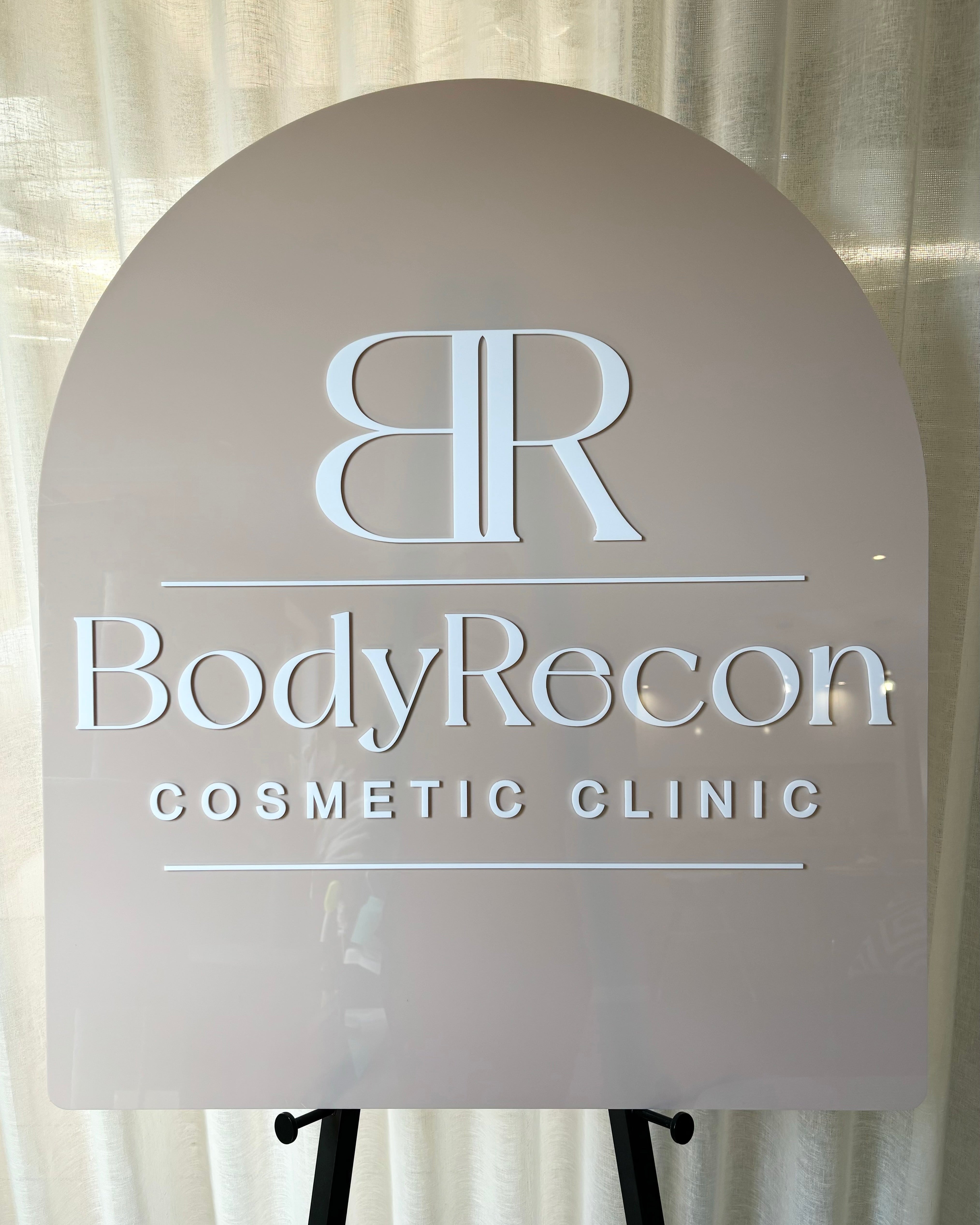 Brown acrylic arch with cosmetic clinic name