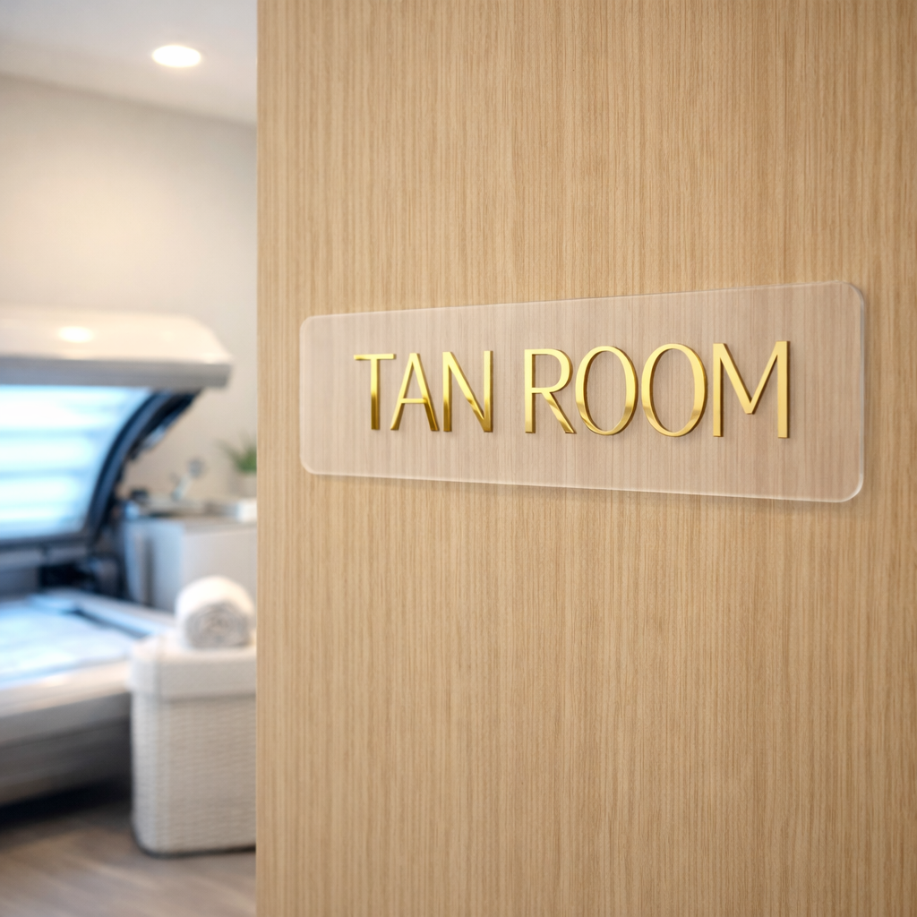 Clear acrylic room sign with raised gold lettering mounted on wooden door, modern salon and clinic door signage