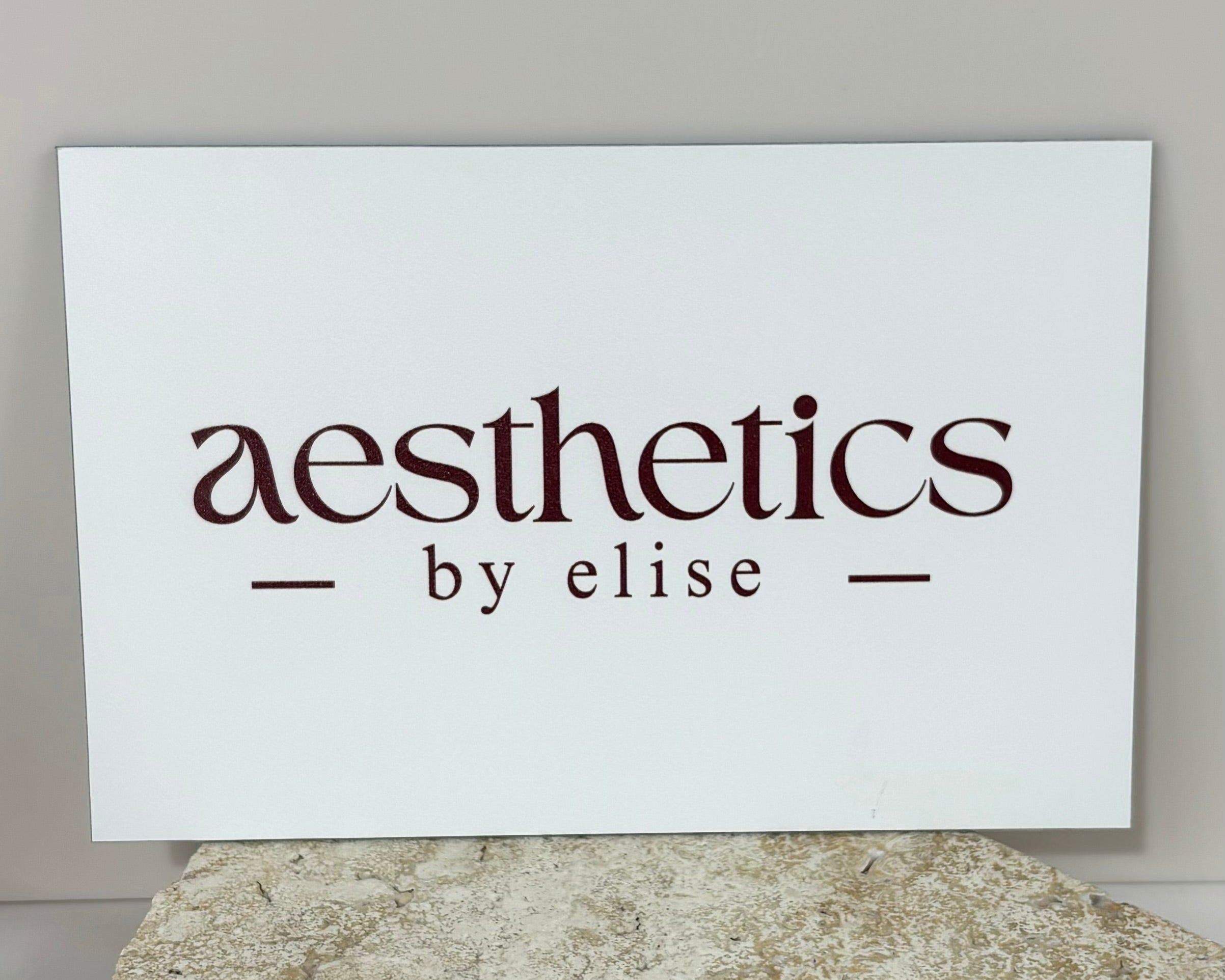 Aesthetics by Elise clinic sign, engraved-style aluminium sign with beauty brand logo, designed for salon reception display.
