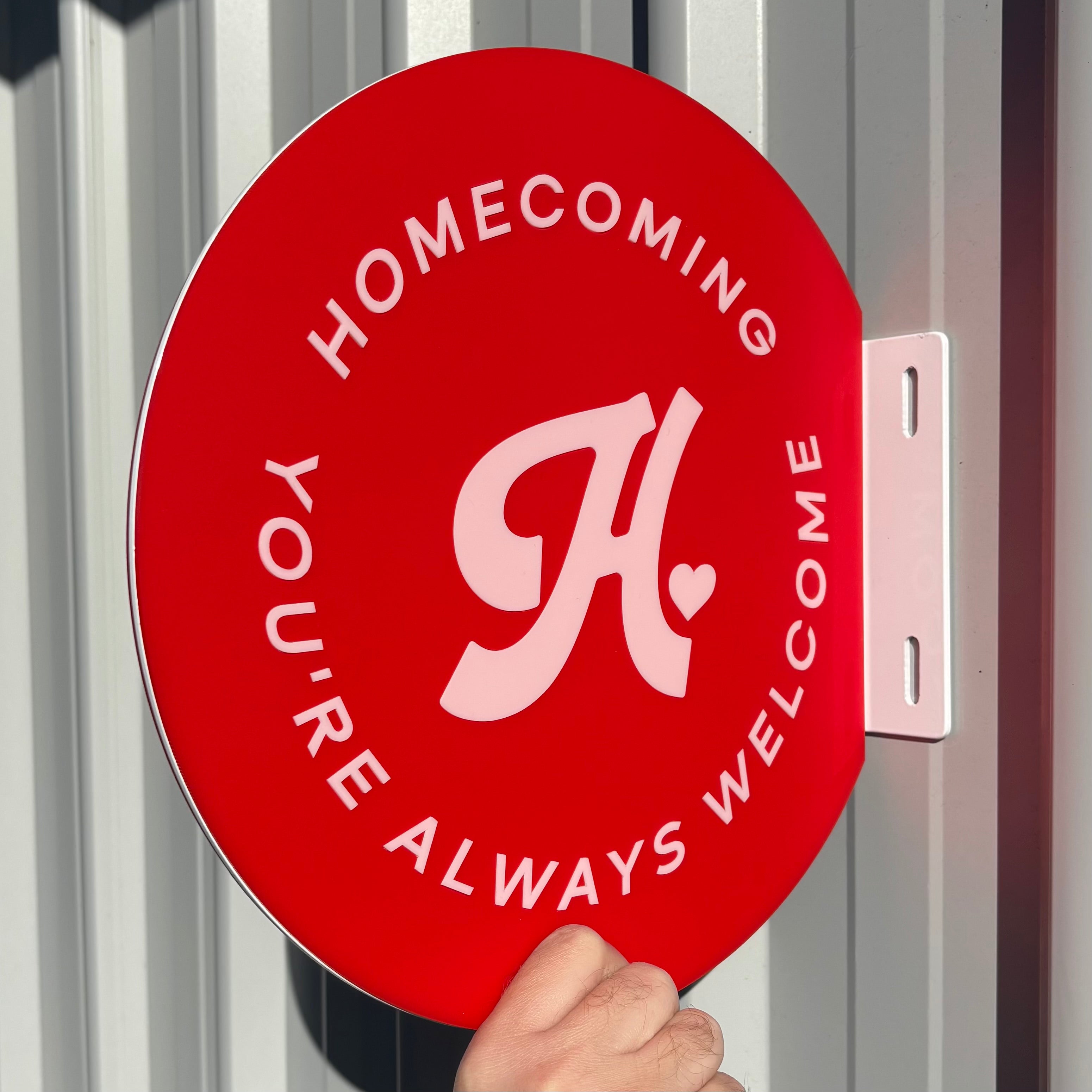 Double sided round shopfront sign installed on building