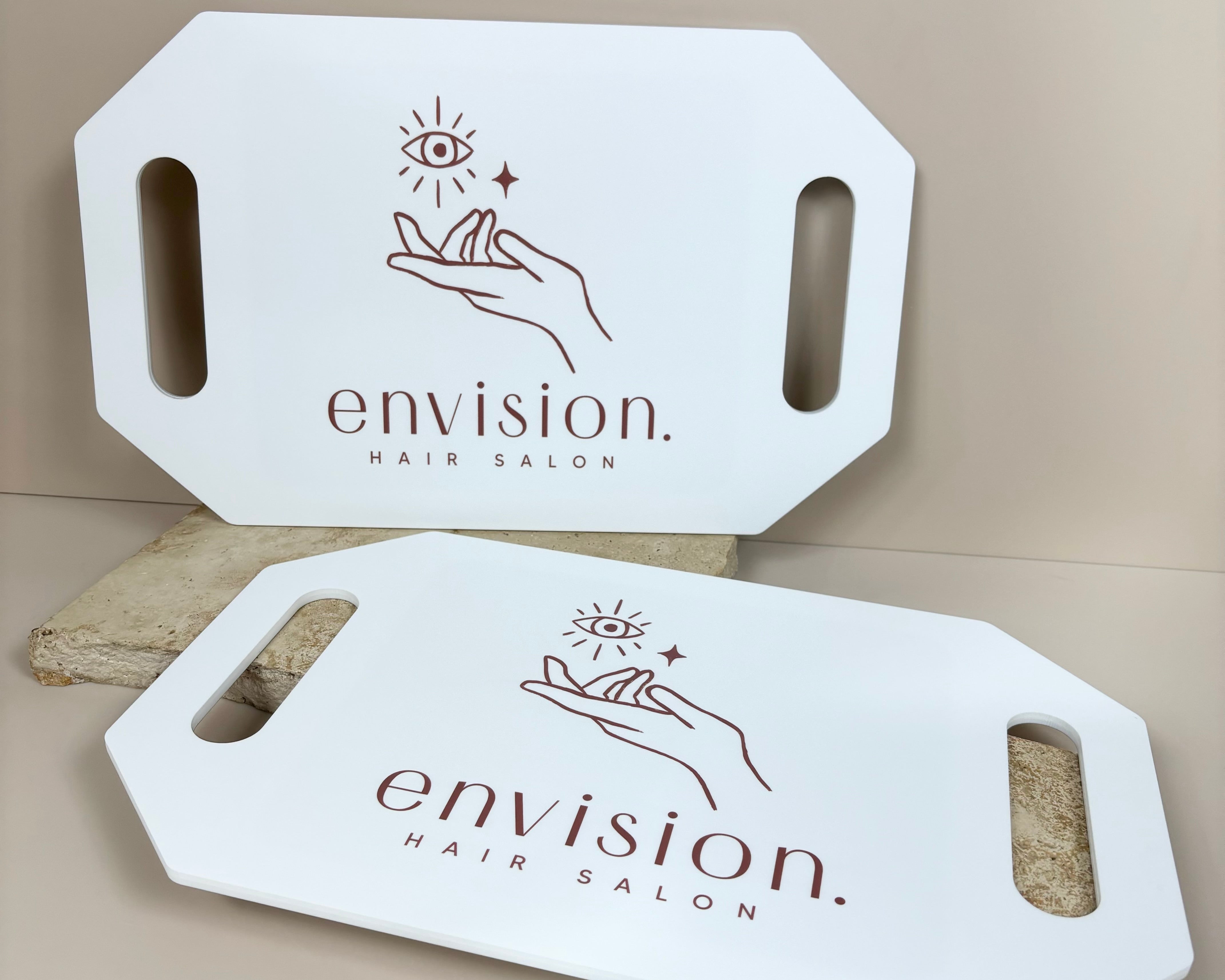 White branded salon mirror with Envision Beauty logo on table