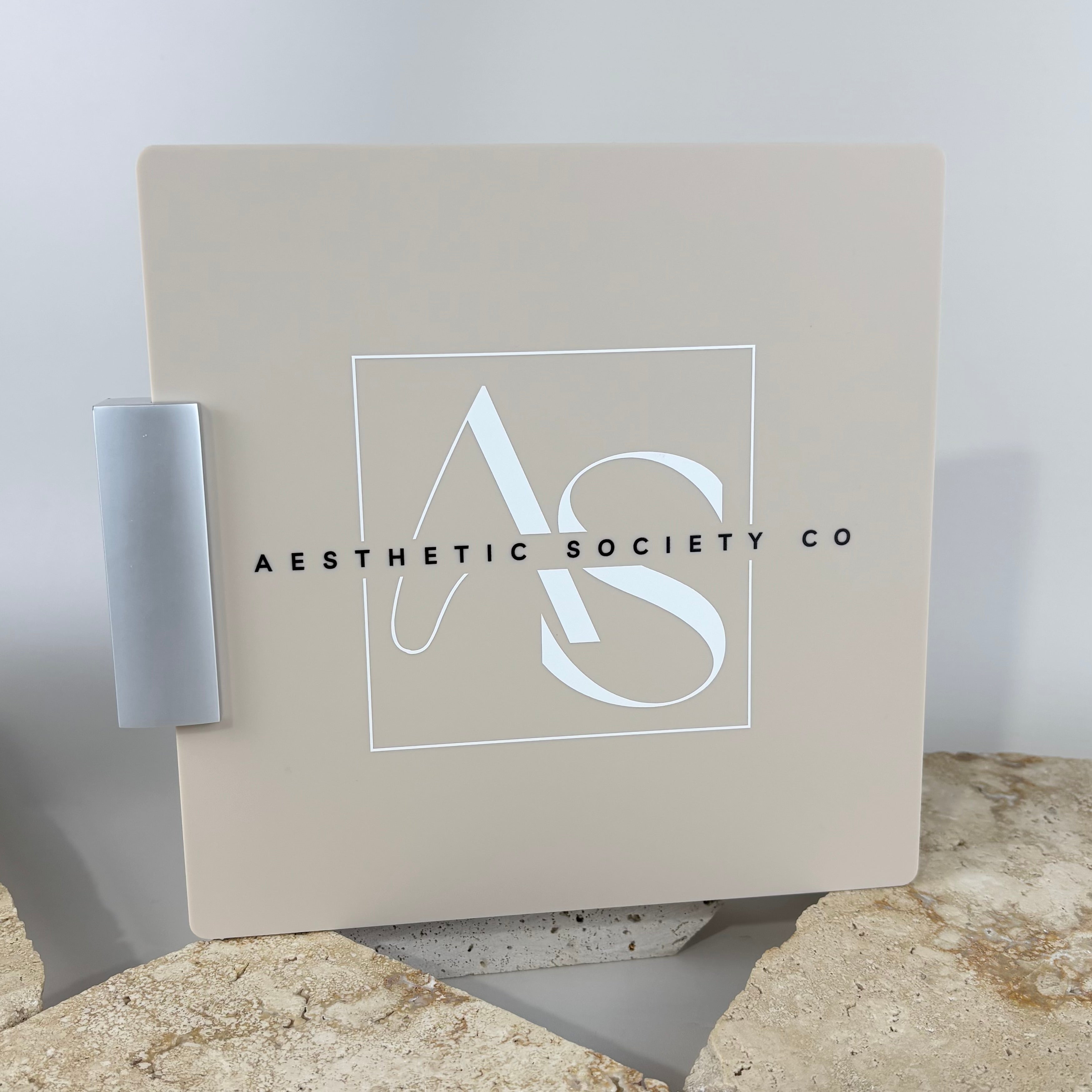 Custom acrylic corridor sign for Aesthetic Society Co with modern logo design in beige and white, perfect for salon and clinic branding.