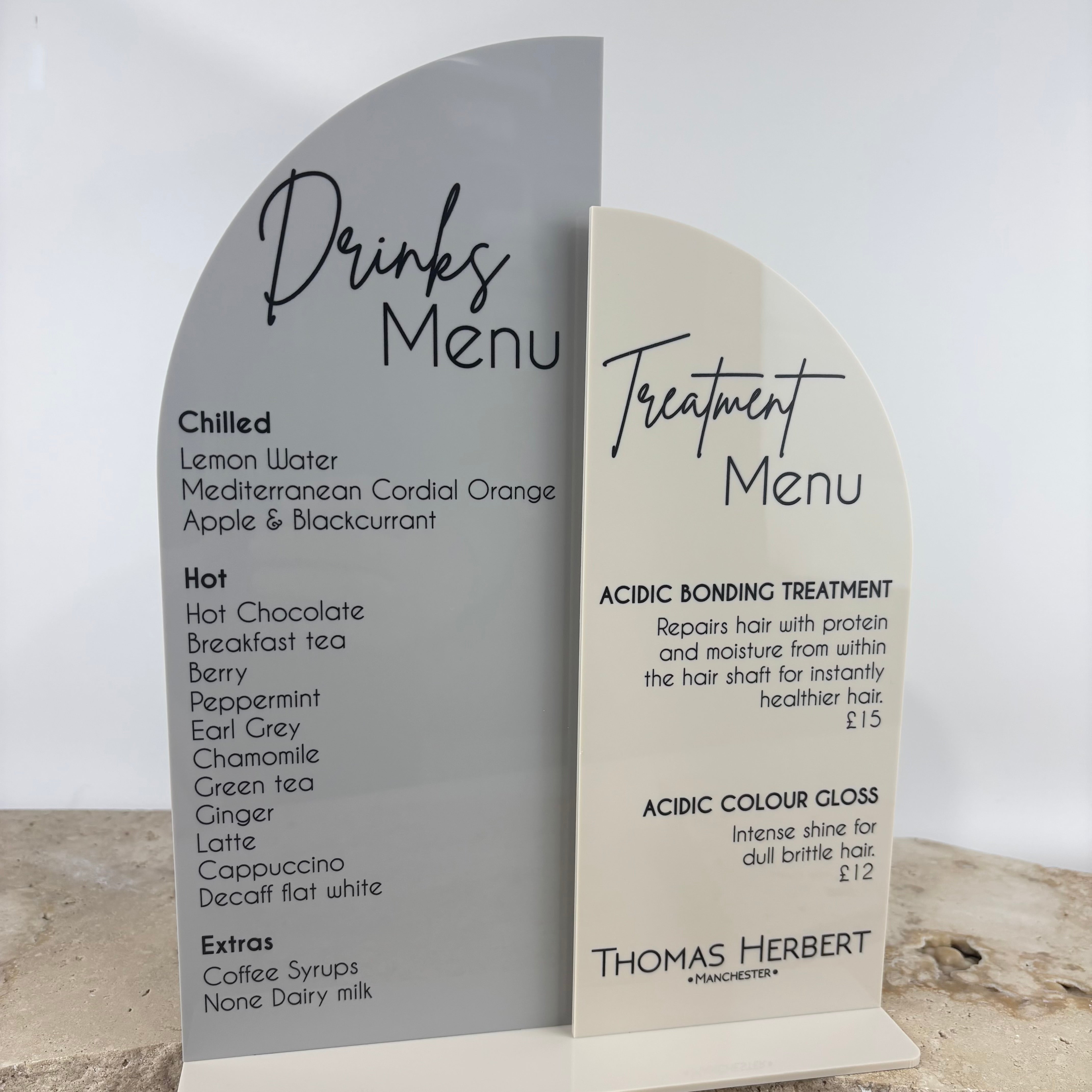 Custom acrylic arched drinks menu and treatment menu sign set, UV printed in black on white and grey acrylic, modern salon signage display with freestanding base, perfect for hair salons, beauty clinics and reception counters in Australia.
