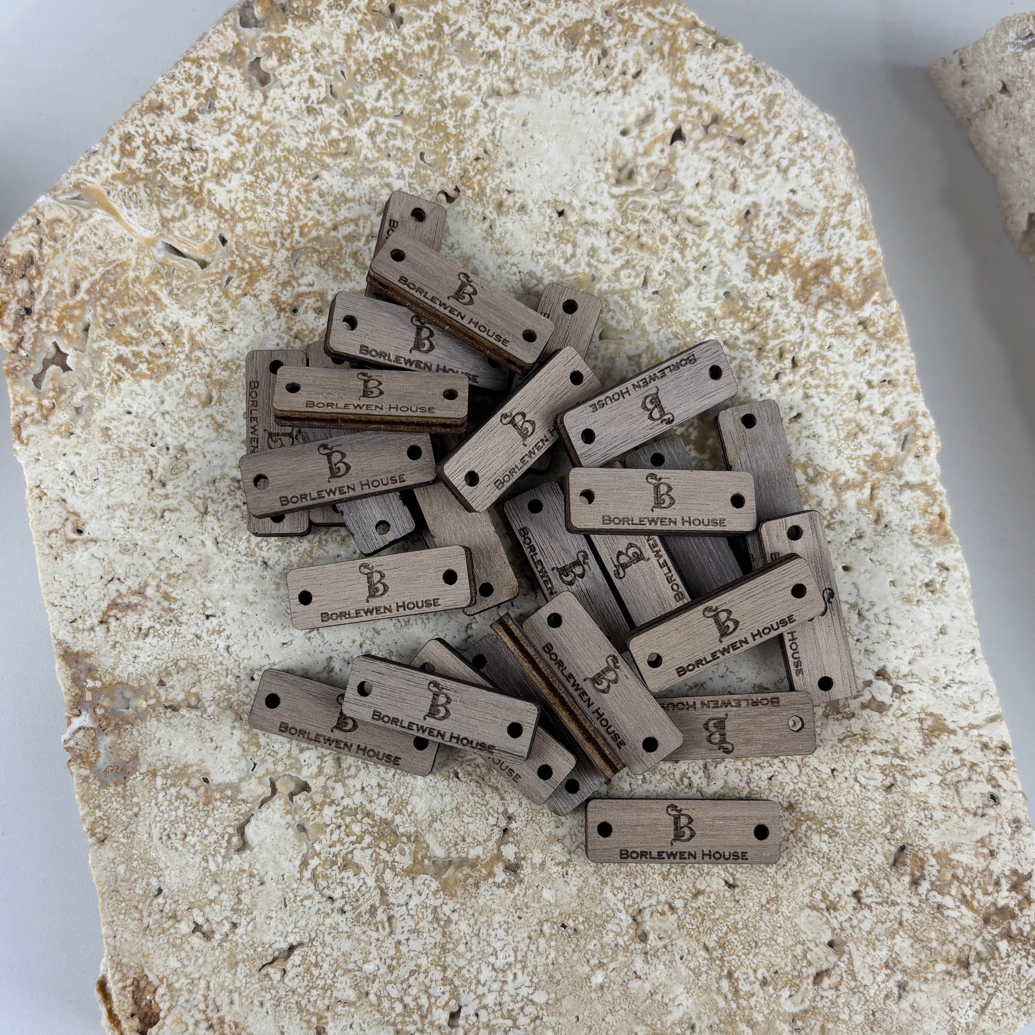 Custom engraved timber tags with logo branding for clothing labels, handmade product tags, boutique swing tags and small business packaging accessories in Australia. Laser engraved wooden rectangle tags with pre-cut holes for sewing onto garments, hats, bags and custom fashion branding.