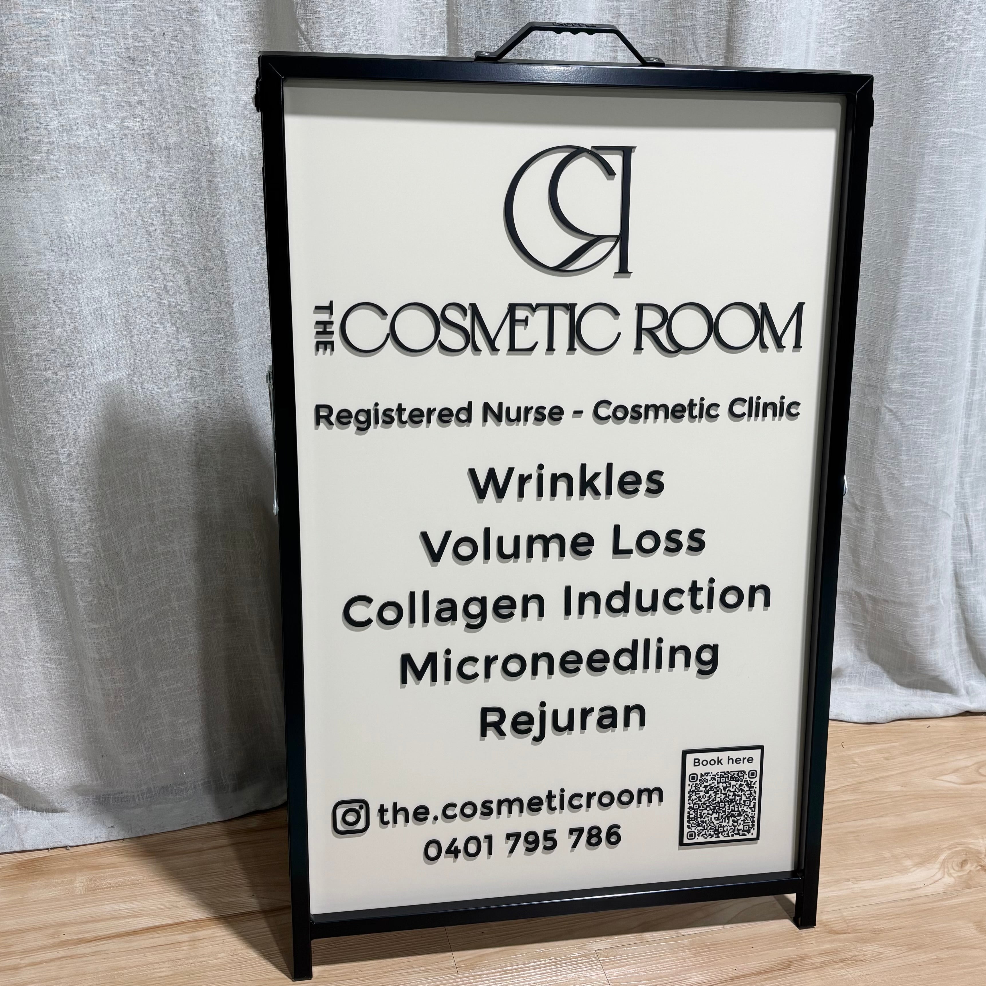 Black A-frame sidewalk sign with UV printed and 3D acrylic lettering for The Cosmetic Room registered nurse cosmetic clinic, featuring a QR code, custom business branding and premium outdoor pavement signage for beauty clinics, medical aesthetics and