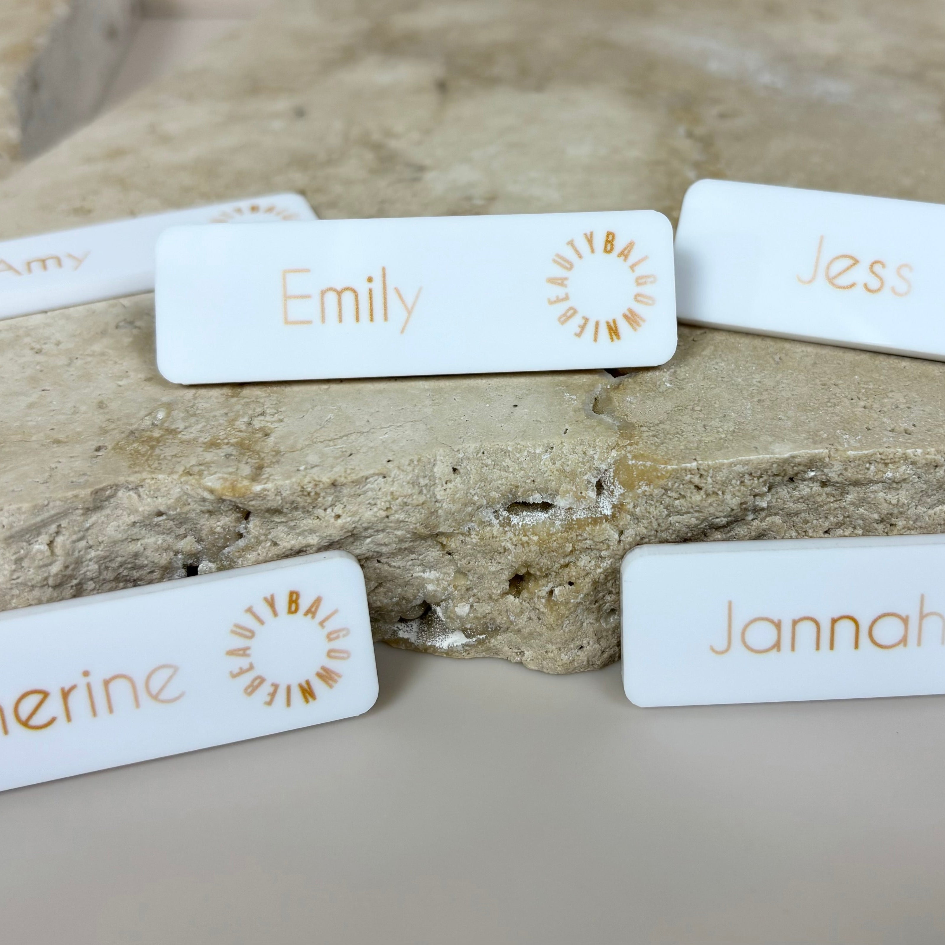 Minimal white name badges with printed staff names