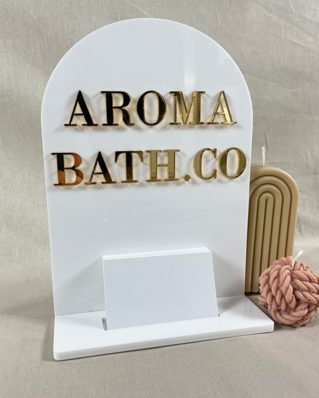 Curved acrylic card stand with Aroma Bath Co logo and card slot