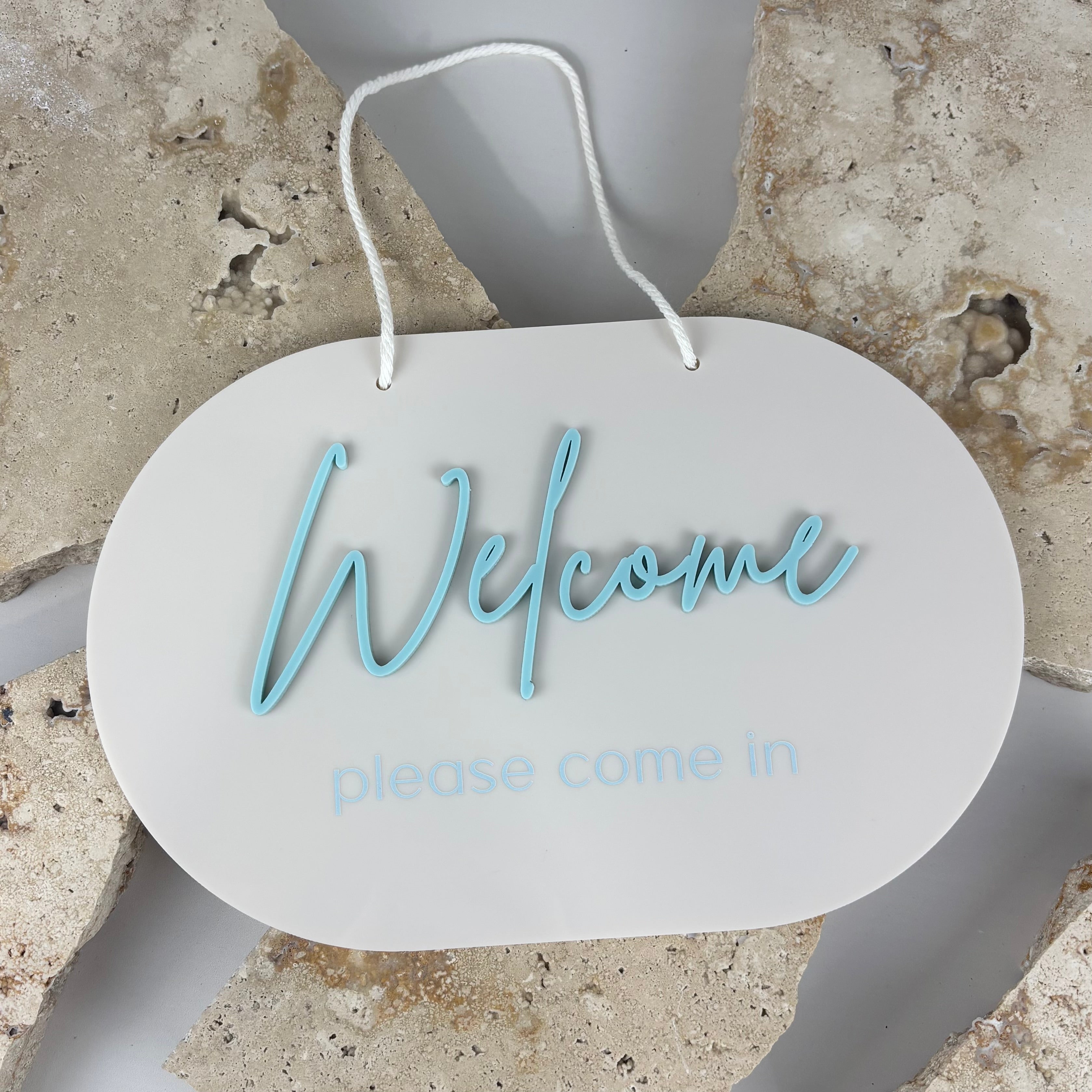 Oval acrylic welcome sign with raised blue lettering reading “Welcome please come in”, hanging door sign for business entrance or reception area