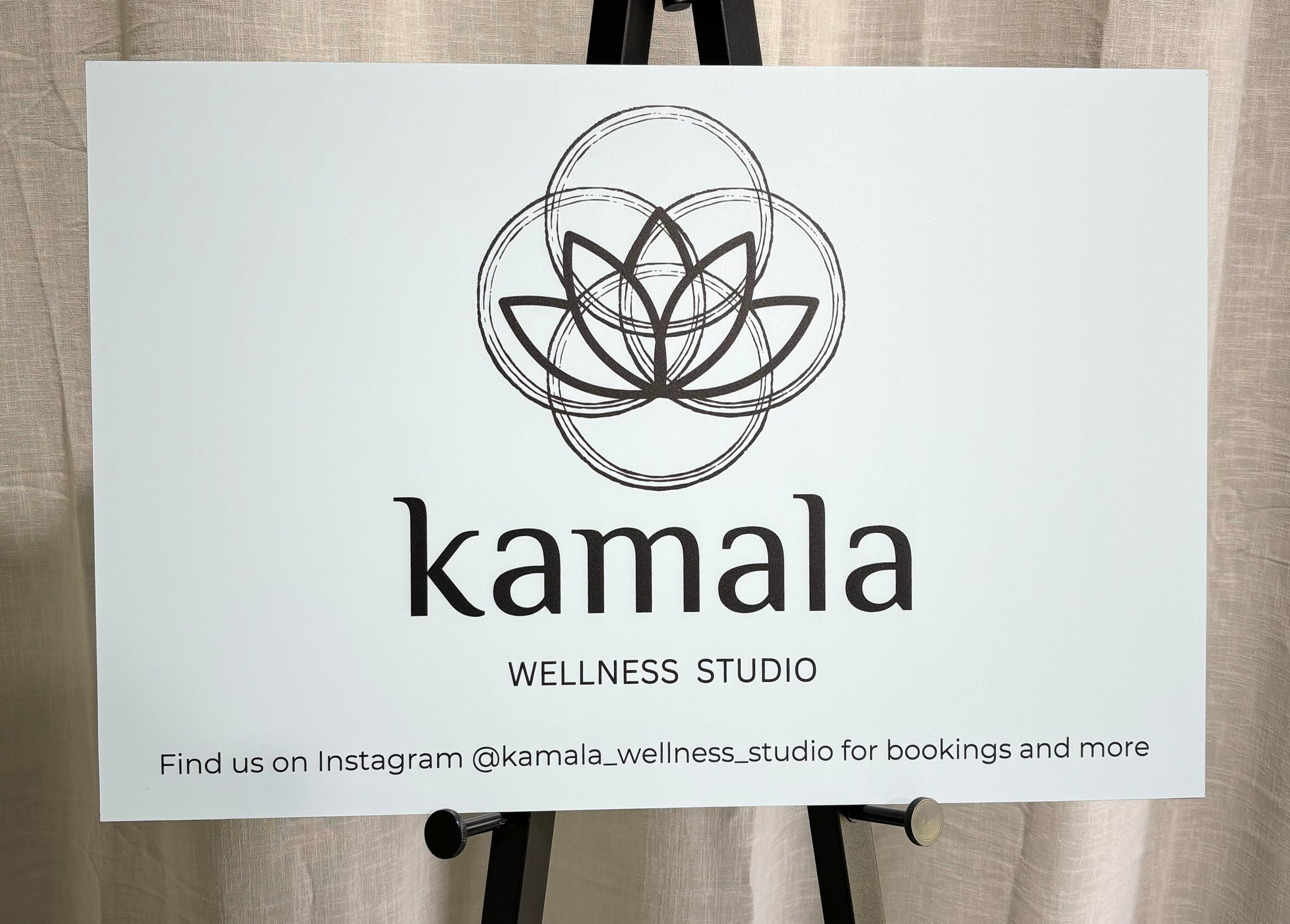 Kamala Wellness Studio aluminium sign, minimalist white aluminium sign with mandala-style logo, suited for wellness and spa studios.