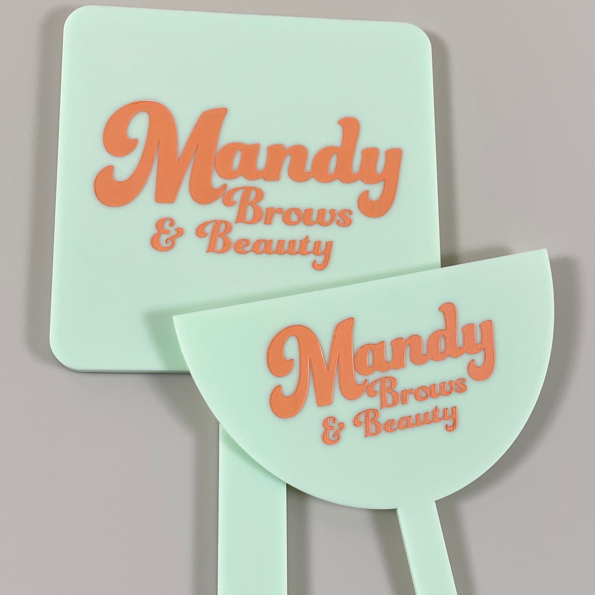 Mint green lash mirror and face shield set with bold orange Mandy Brows & Beauty branding