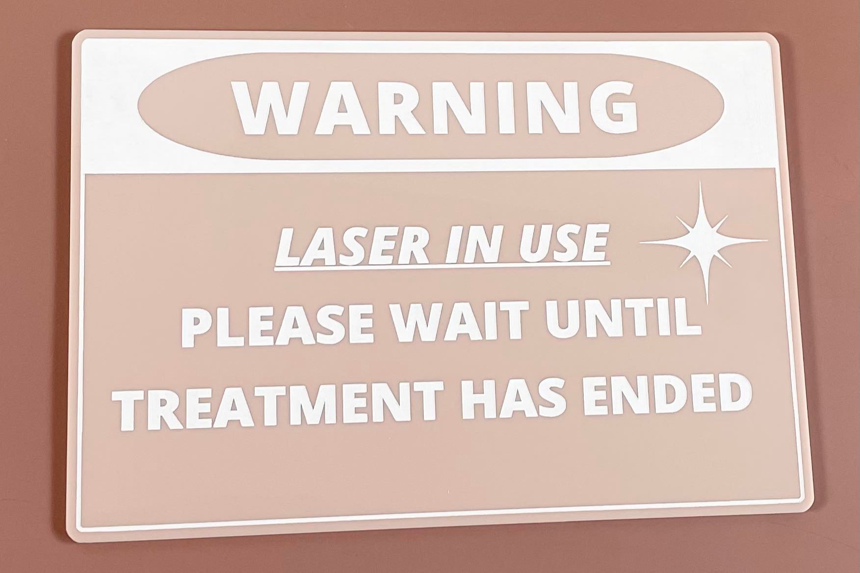 Beige acrylic laser in use warning sign, personalised for beauty salon safety.