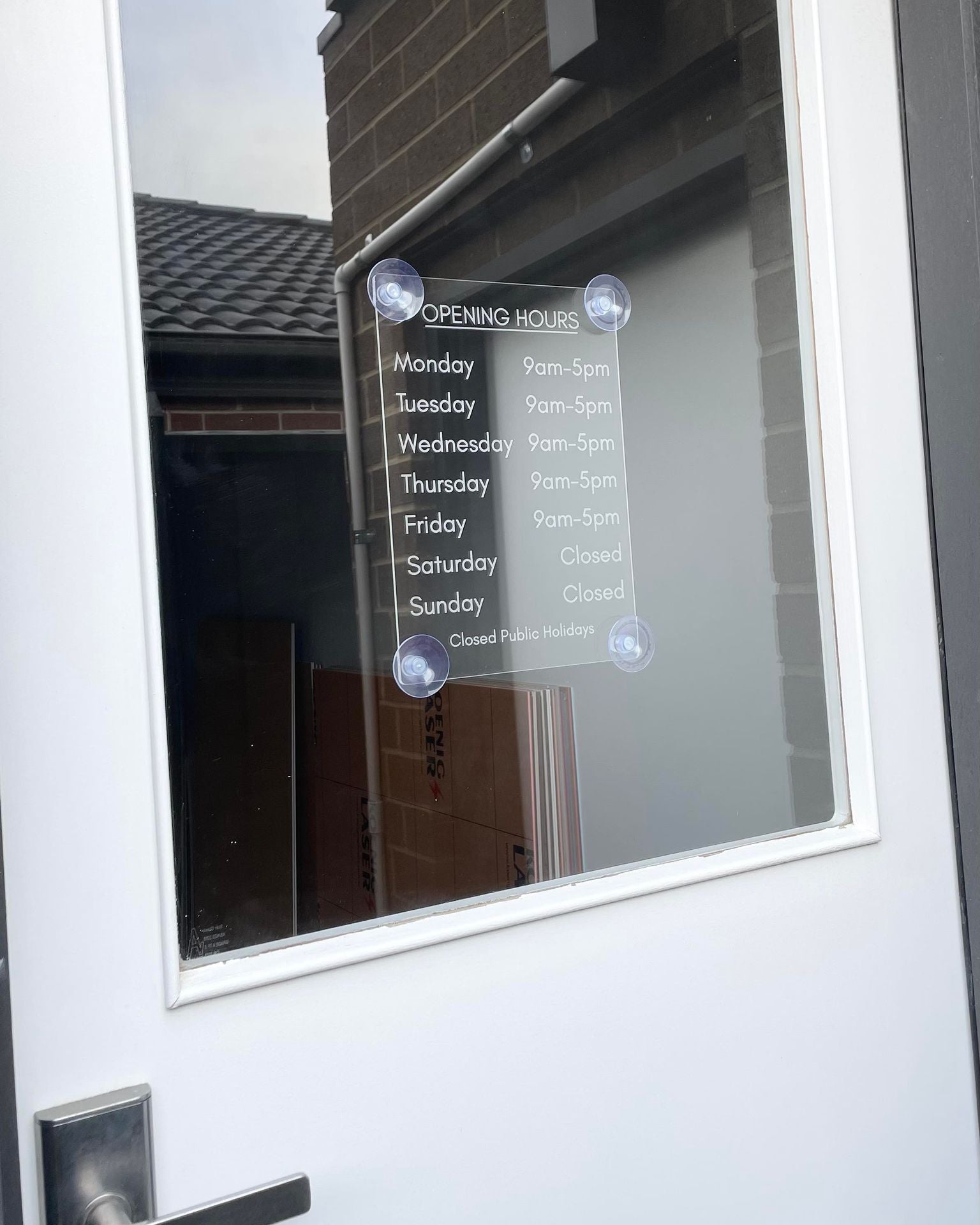 Modern acrylic opening hours sign mounted on window – custom business hours display
