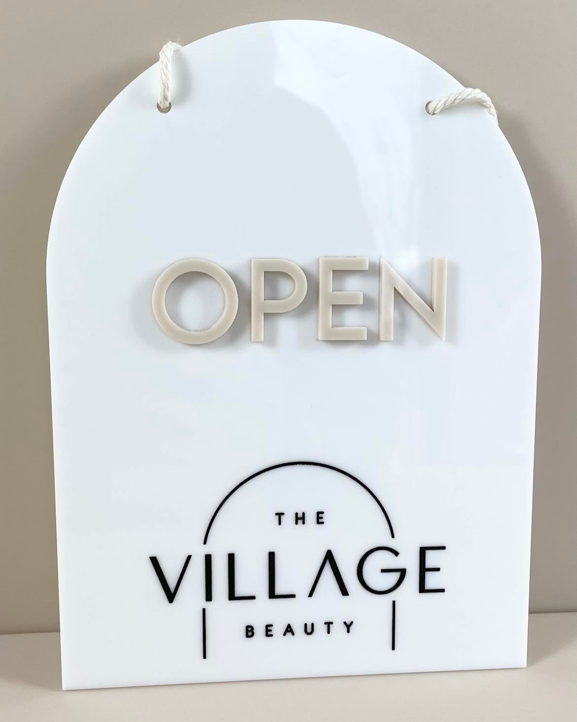 Arched white acrylic open sign with beige raised letters – salon front door sign