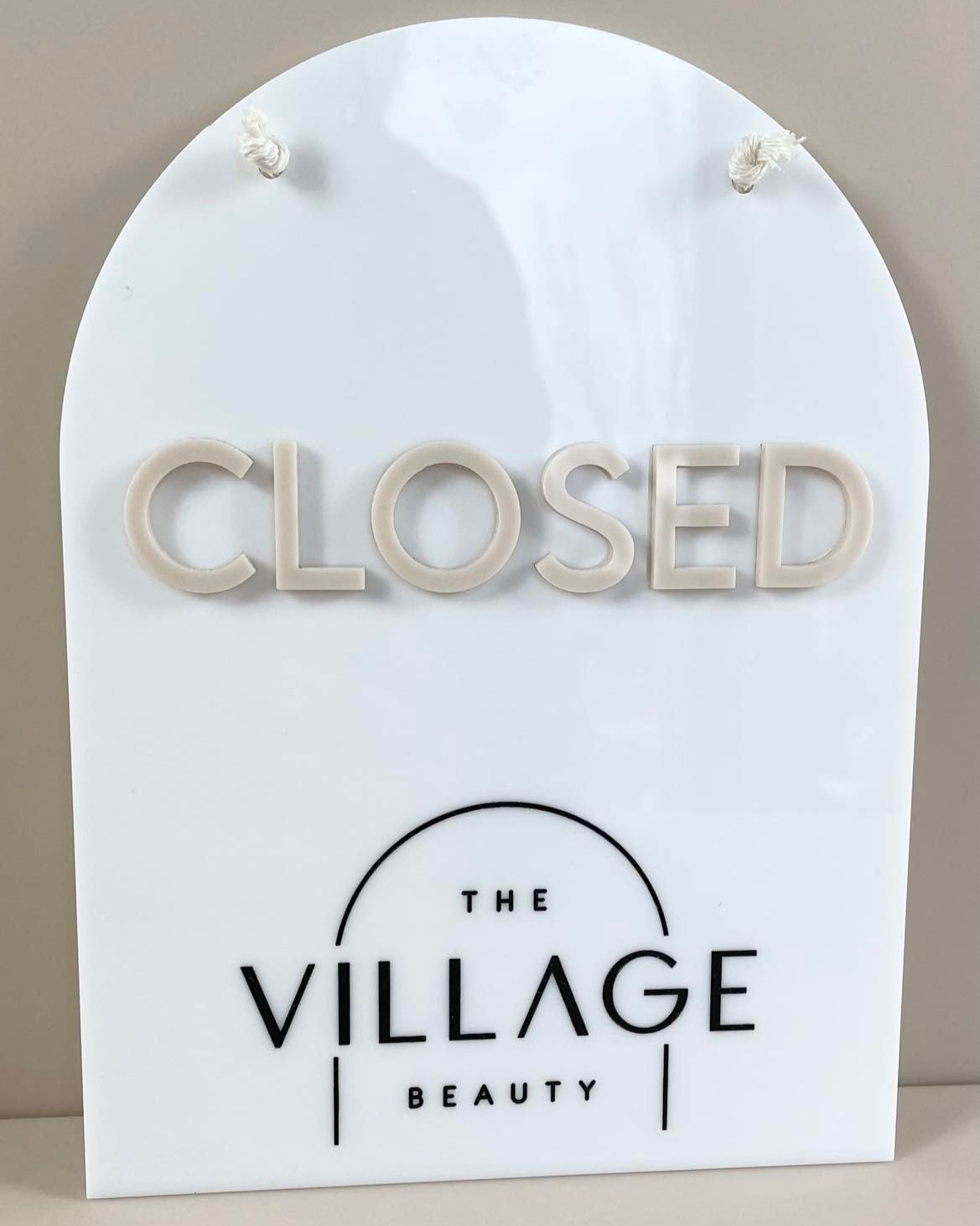 Arched white acrylic closed sign with beige raised letters – custom beauty sign
