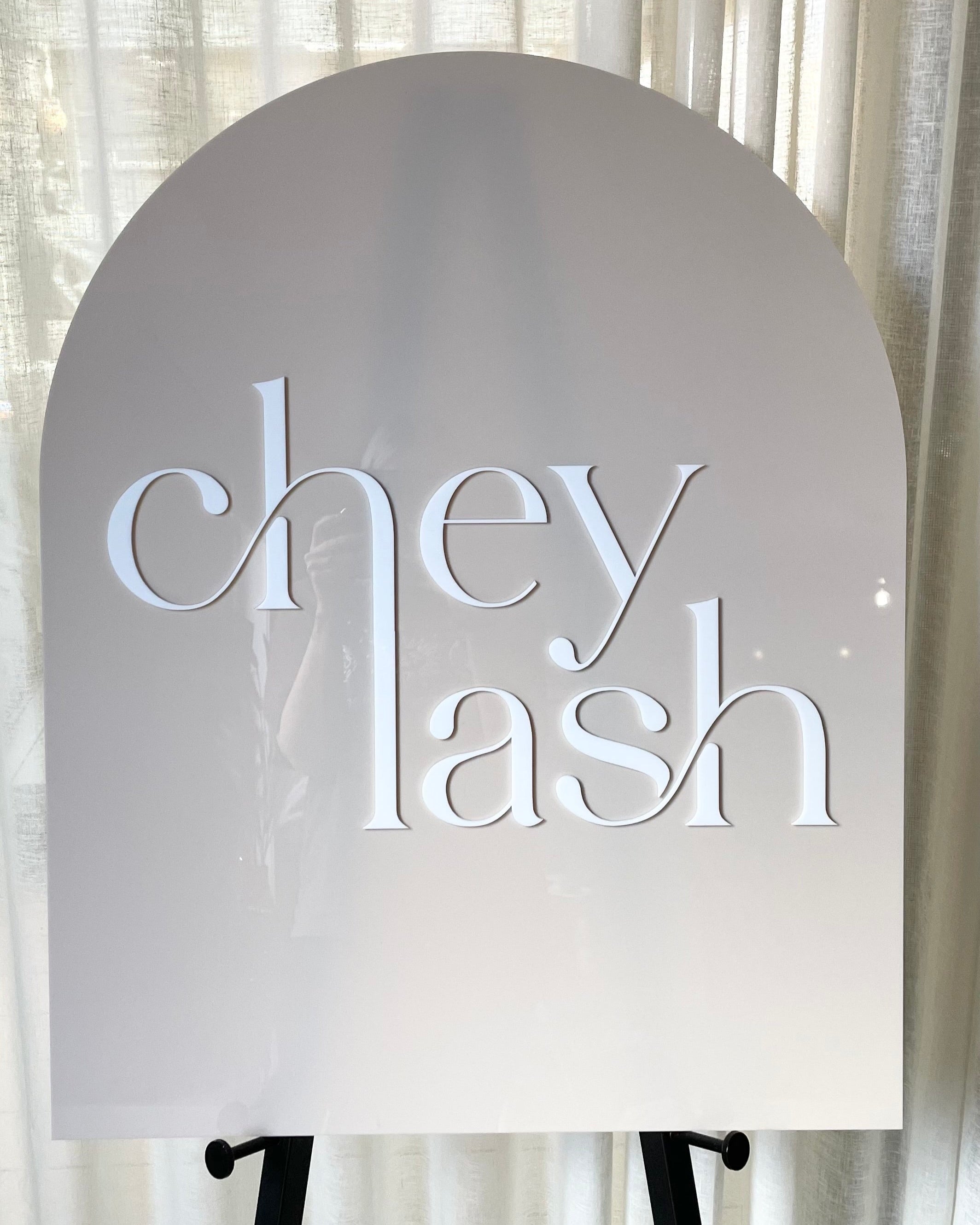 Beige acrylic arch sign for lash salon branding