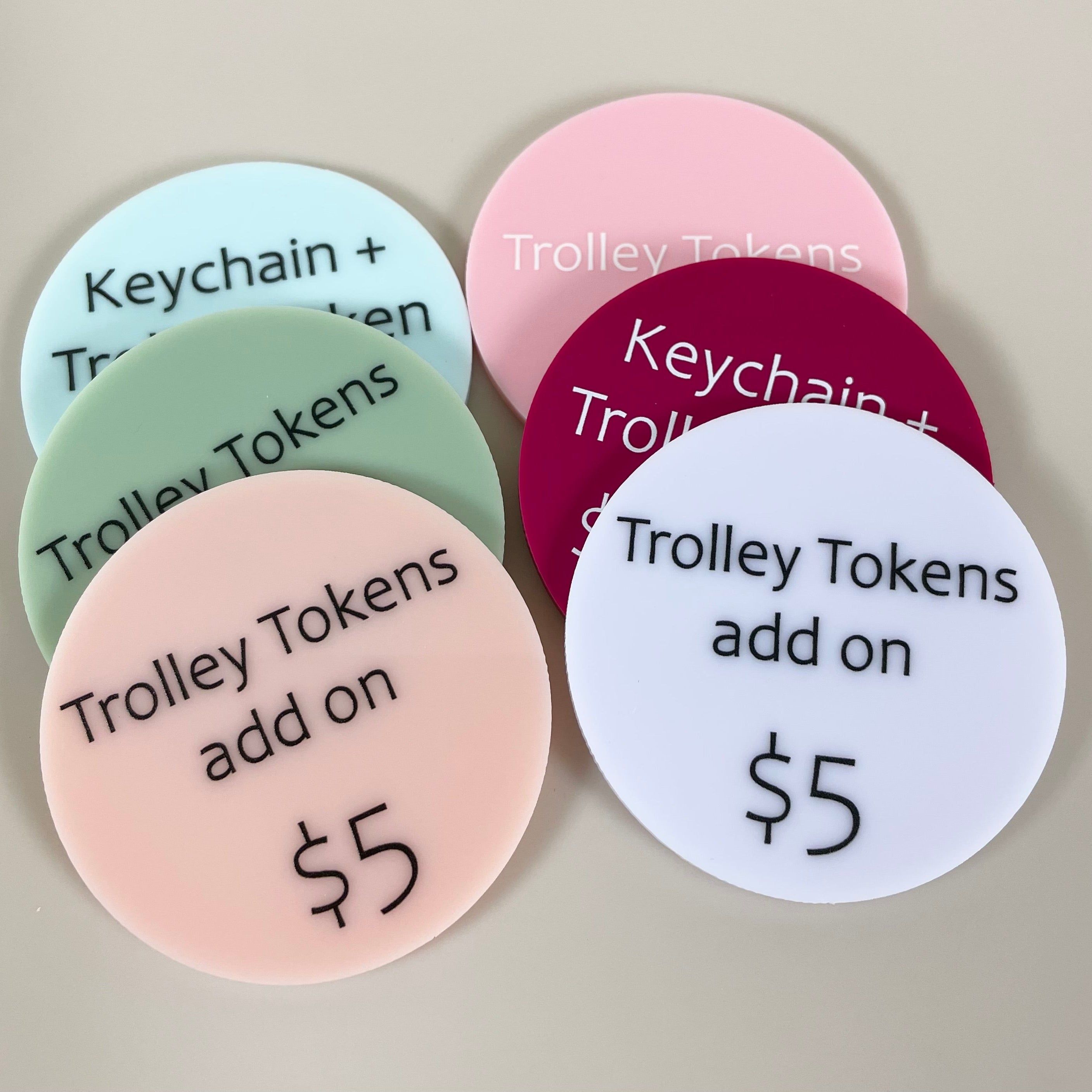 Pastel acrylic price discs labelled Keychain and Trolley Tokens with $5 price