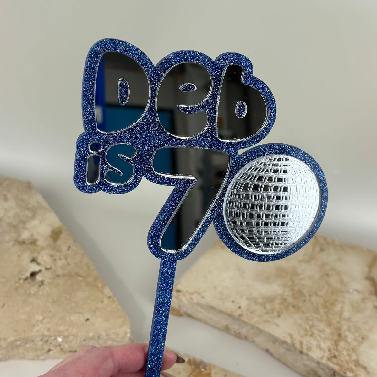 Custom blue glitter and mirror acrylic 70th birthday cake topper with disco ball design.