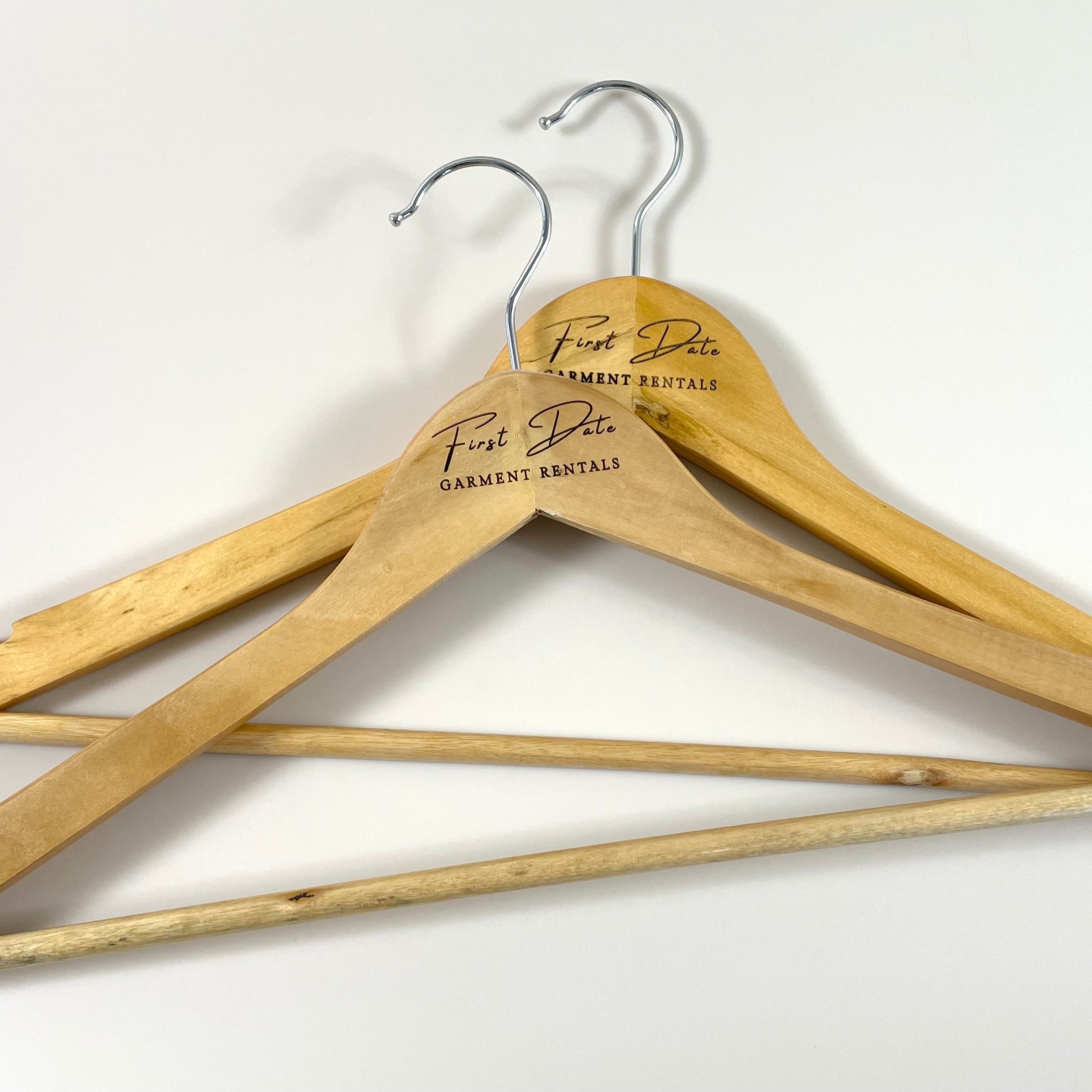 Custom logo coat hangers hanging garments in boutique retail space