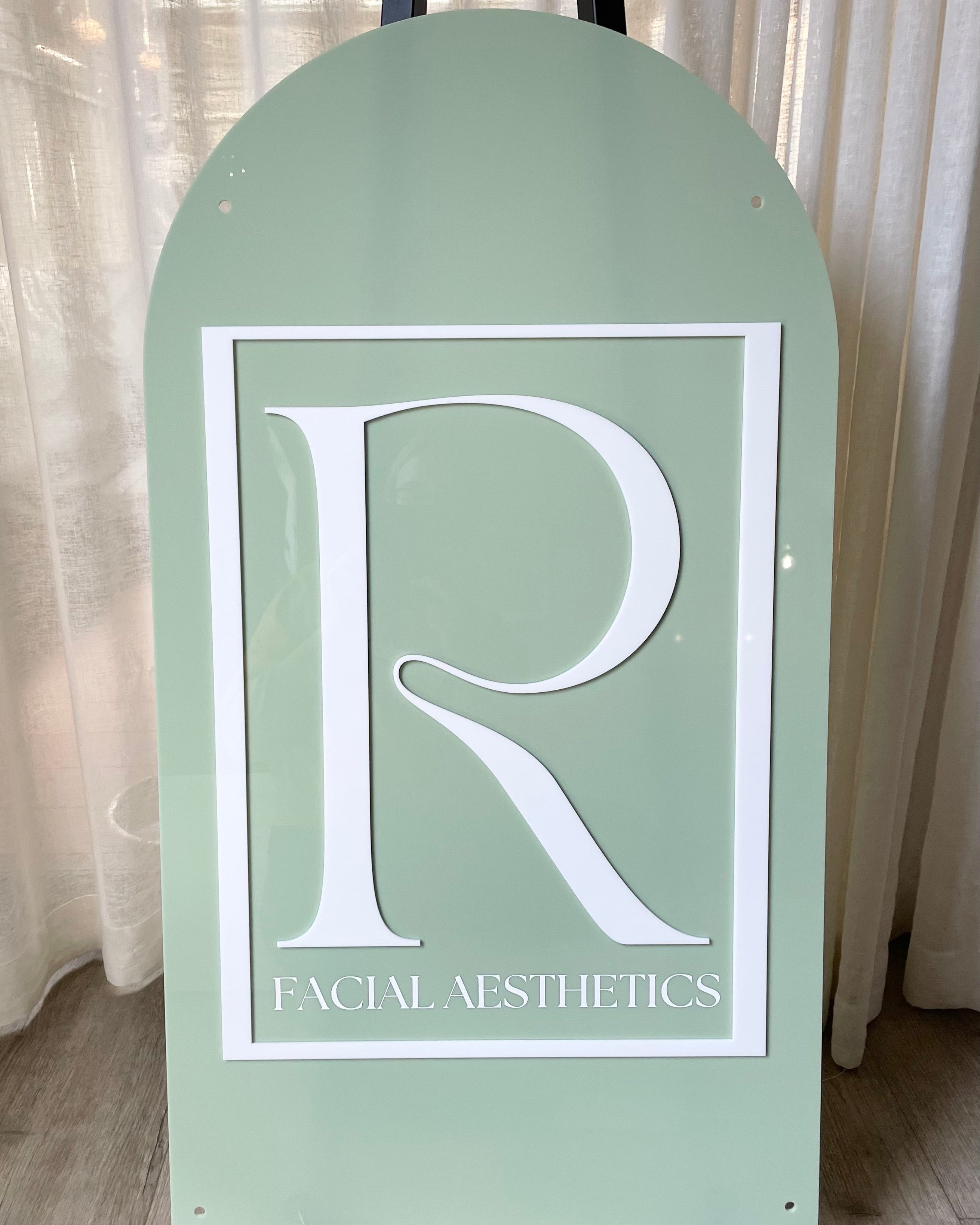 Sage green arch business sign with large monogram R