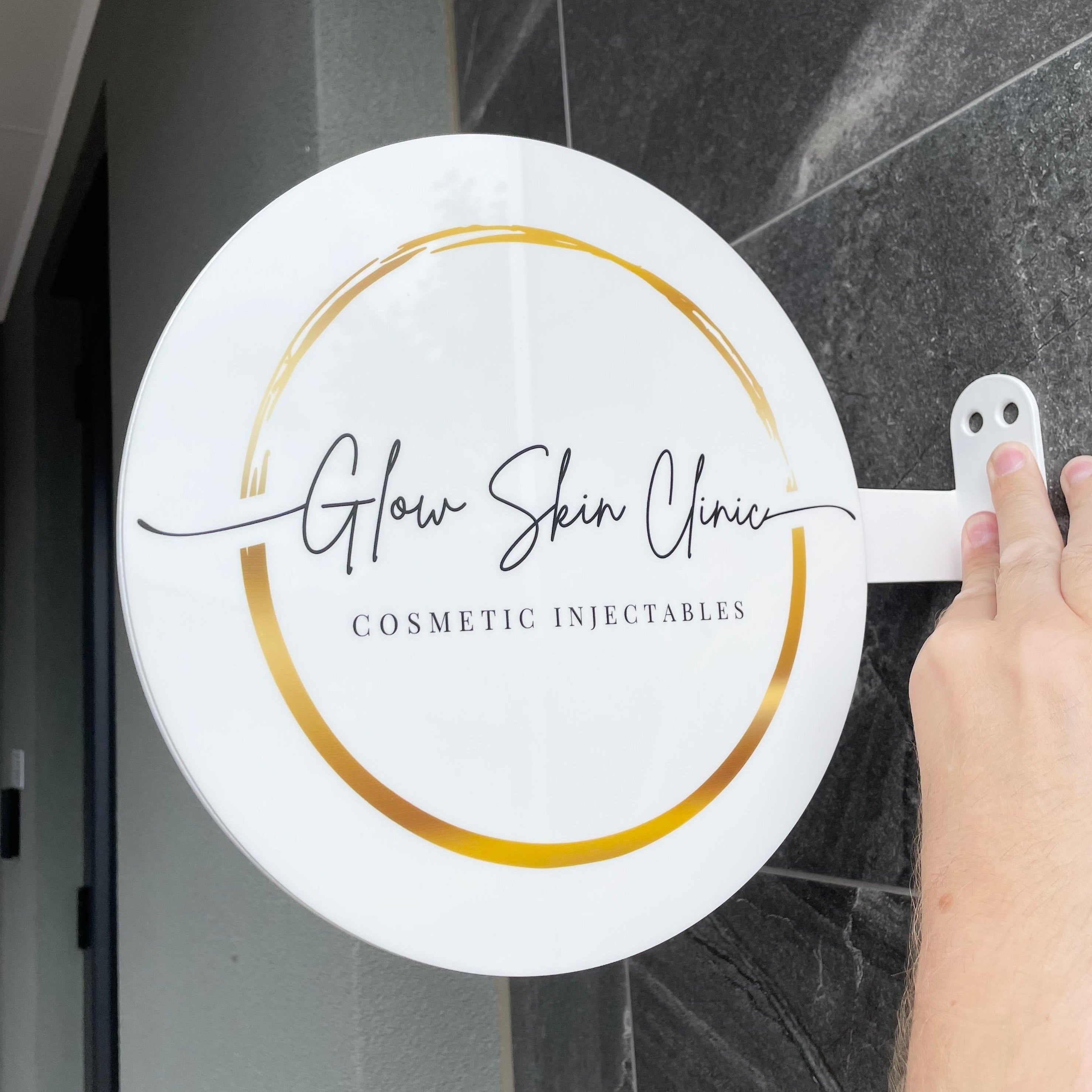 Glow Skin Clinic round hanging sign in white and gold