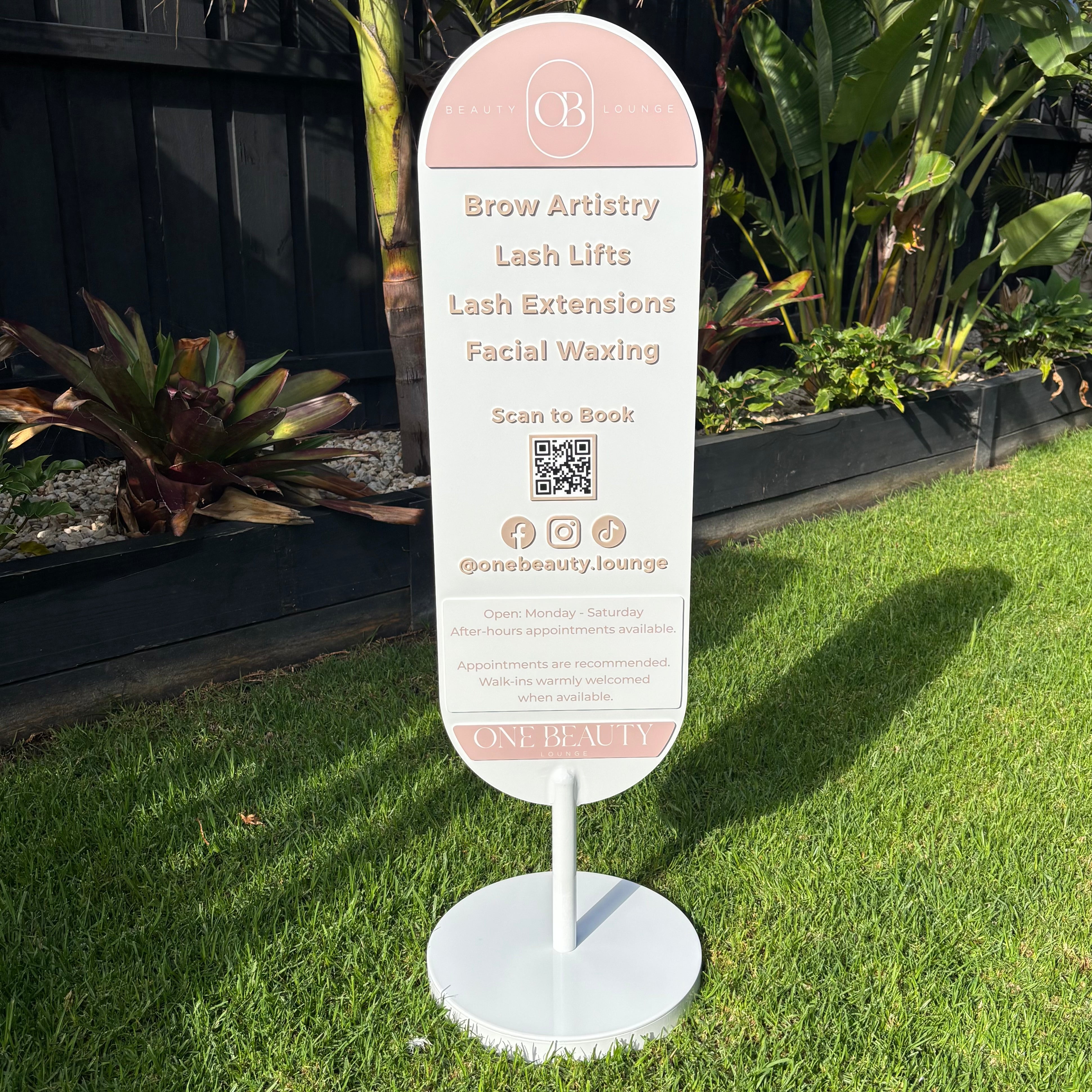 Luxury oval beauty salon pavement sign featuring 3D acrylic lettering, QR code booking sign, social media icons and custom branding. Freestanding white metal display stand for brow artists, lash technicians, beauty salons and cosmetic clinics in Australia.