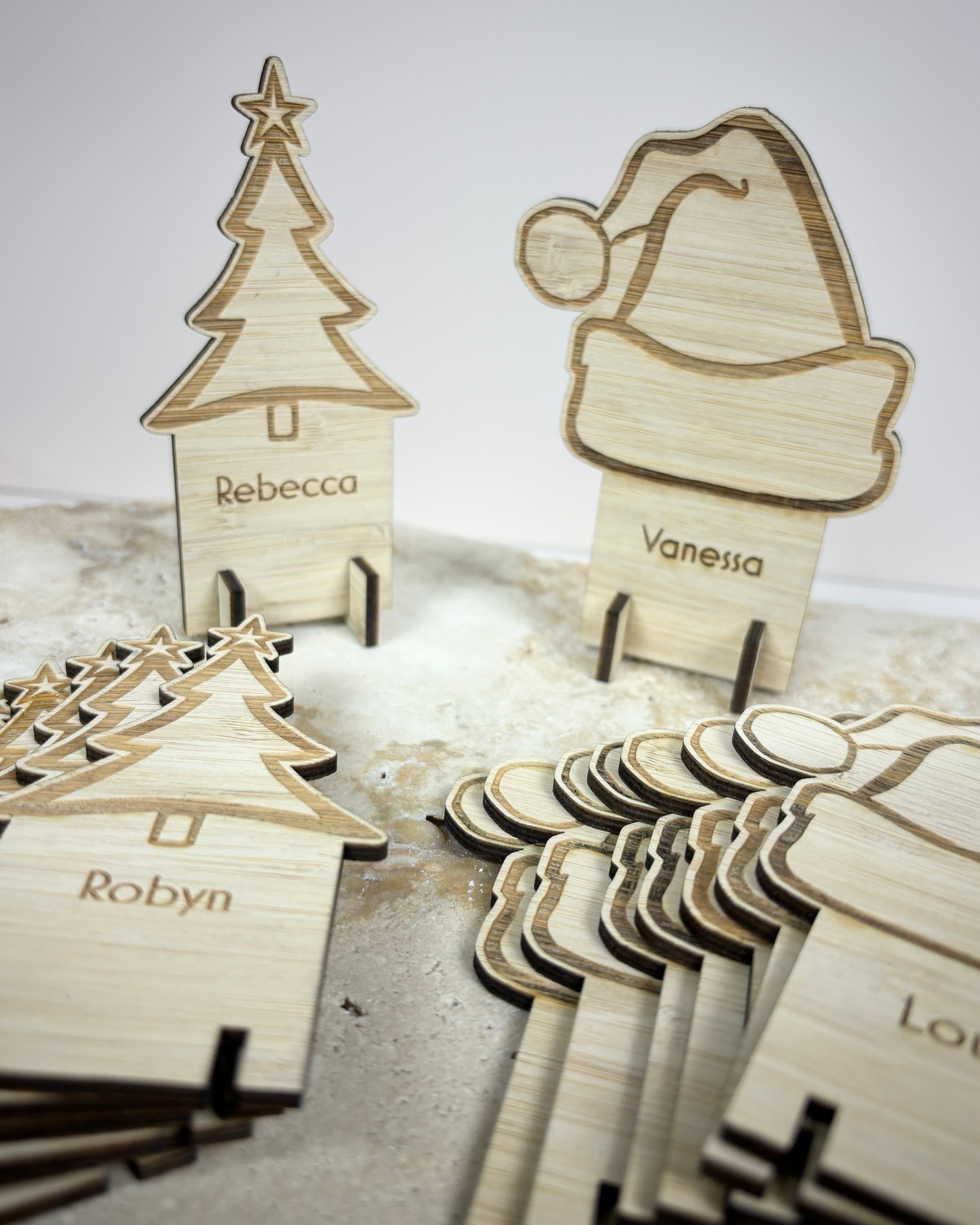 Custom engraved wooden Christmas place cards with assorted festive shapes and personalised guest names