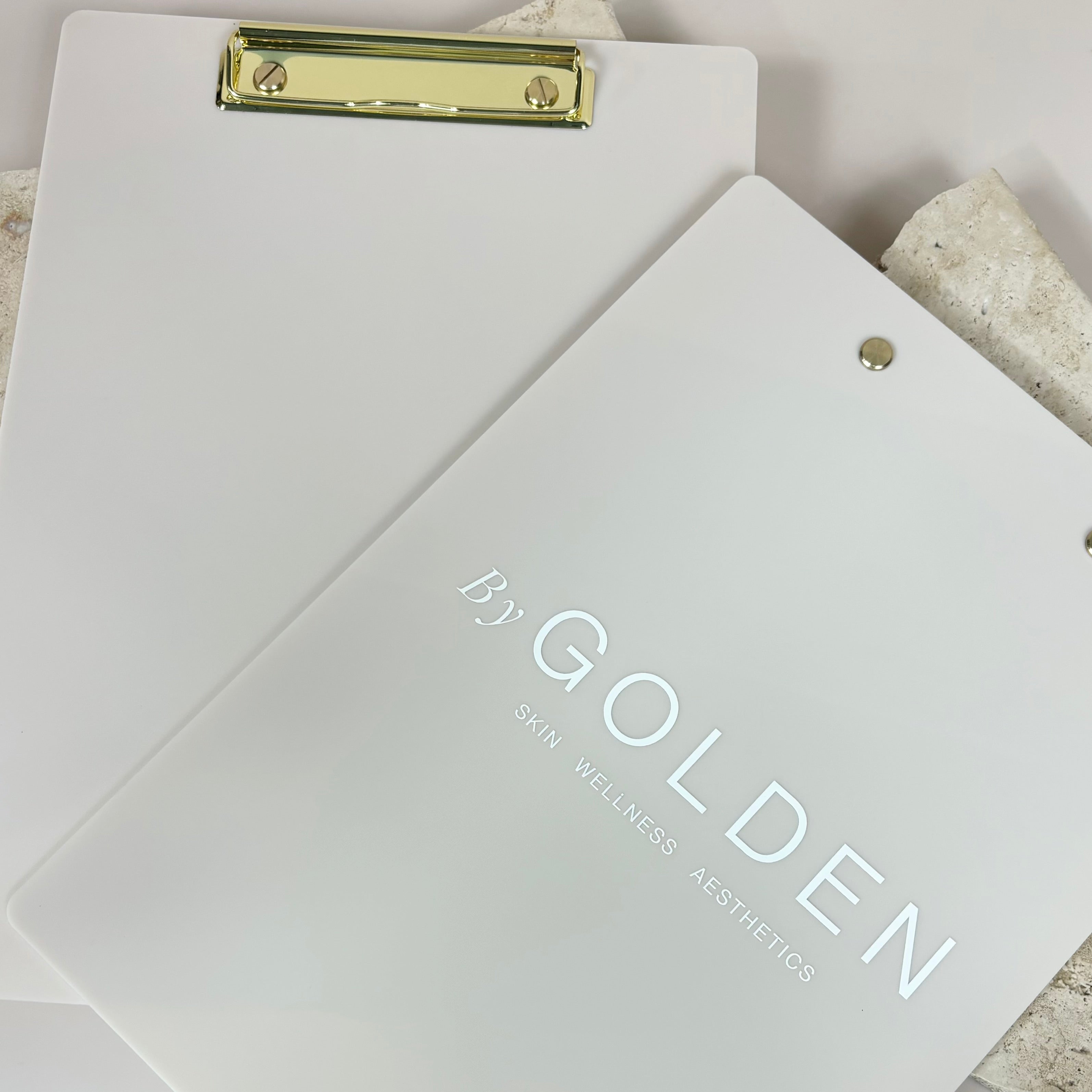 White acrylic clipboard with engraved business logo and gold clip
