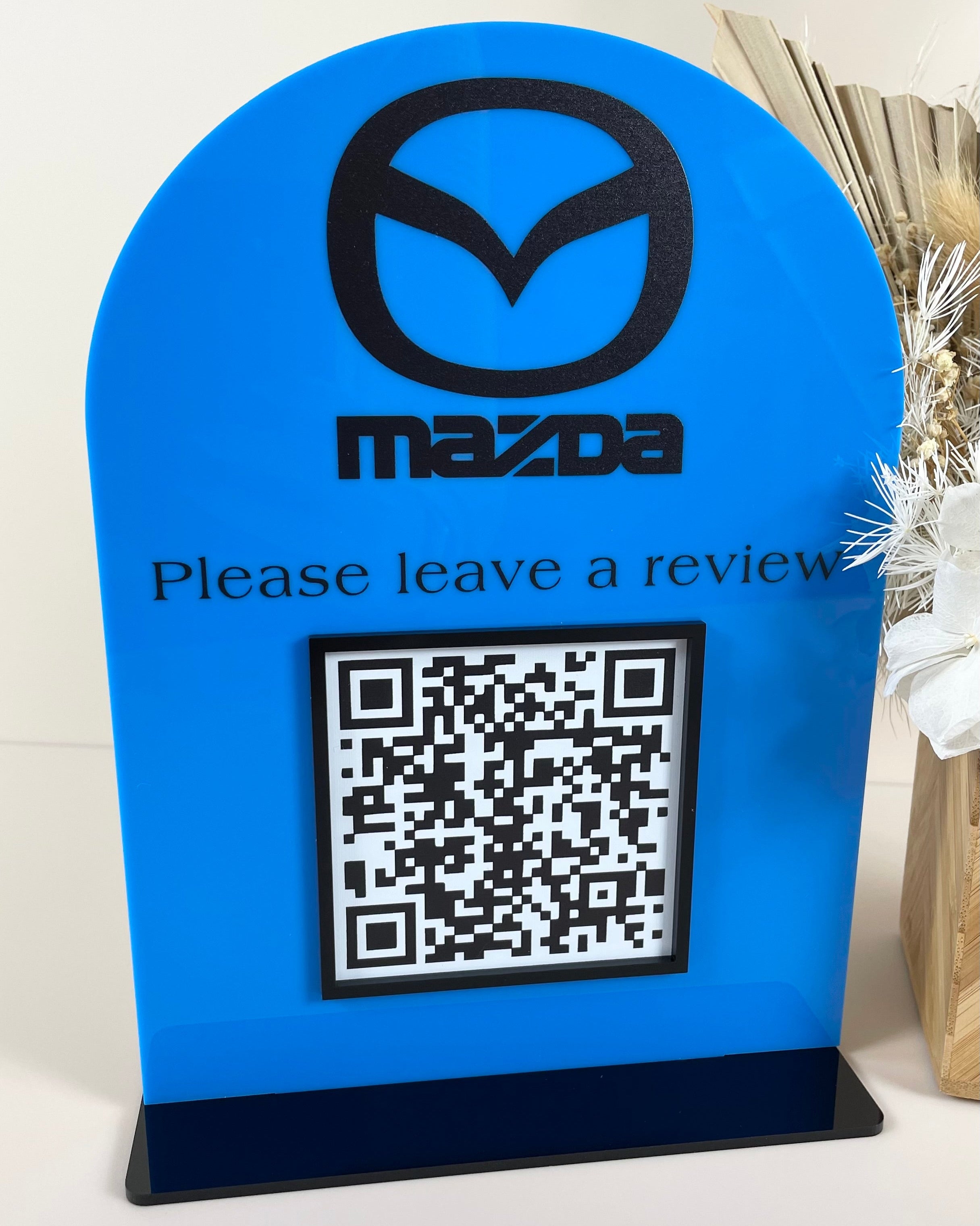 Bright blue branded QR stand for automotive dealership review link