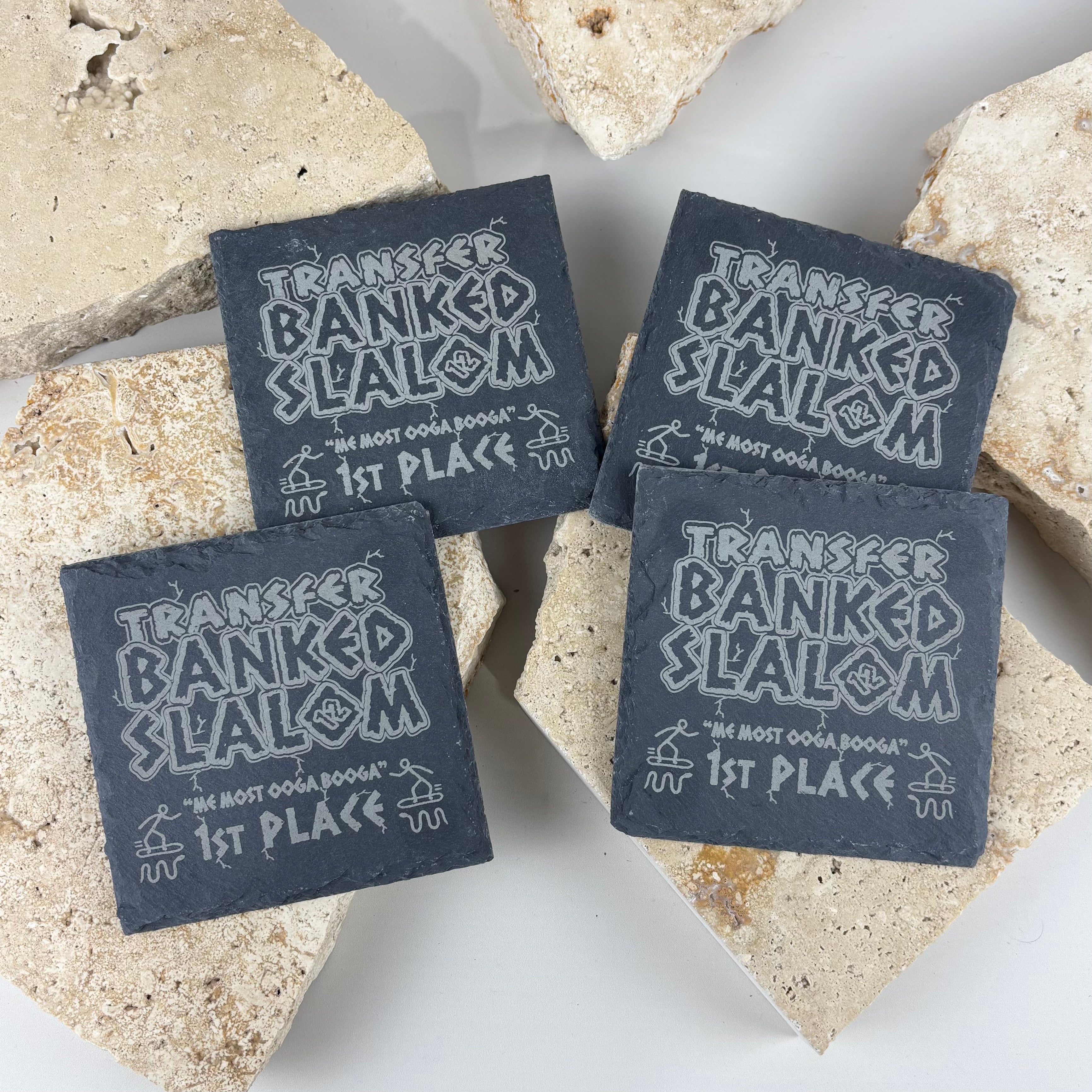 Custom engraved black slate coaster set featuring a personalised award design for Transfer Banked Slalom 1st Place. Premium laser engraved natural slate coasters, perfect for business branding, promotional merchandise, corporate gifts, sporting events, awards, home bars and personalised keepsakes.