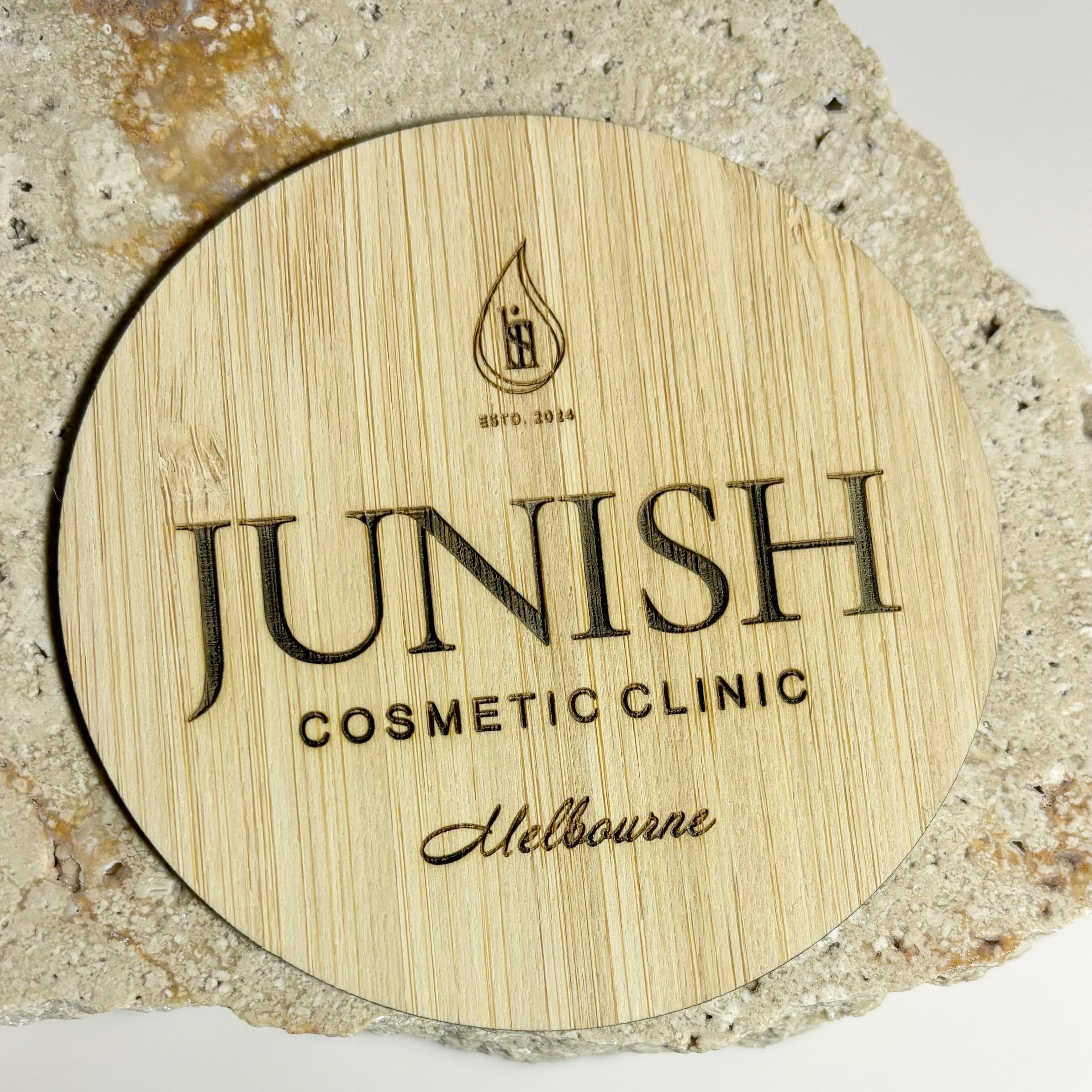 Custom bamboo logo disc engraved with clinic logo – flat lay prop for beauty businesses