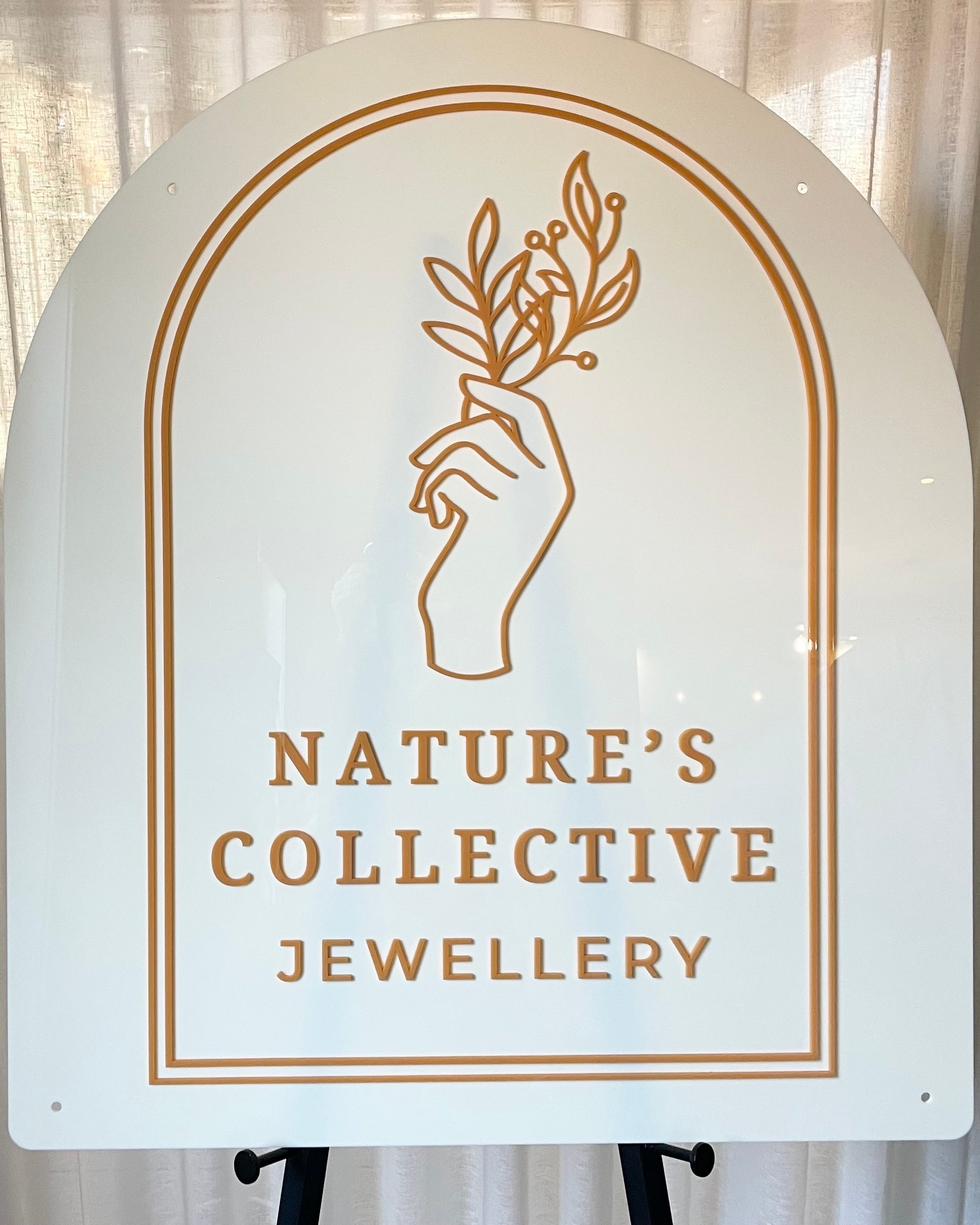 White acrylic arch with orange outline and nature logo