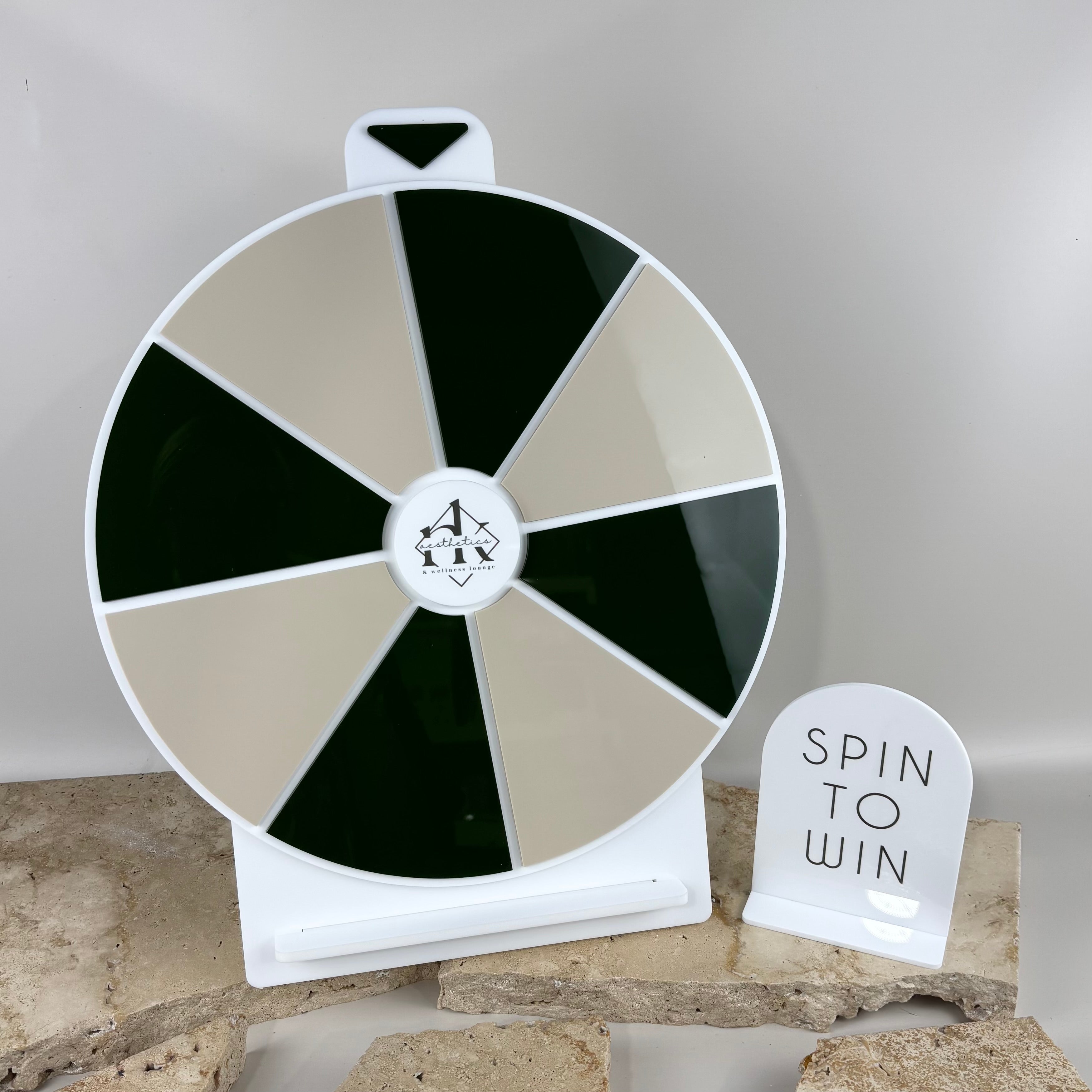 Custom spin the wheel prize display with green and neutral acrylic segments, freestanding promotional game for events and retail marketing, branded spin to win wheel with stand and sign