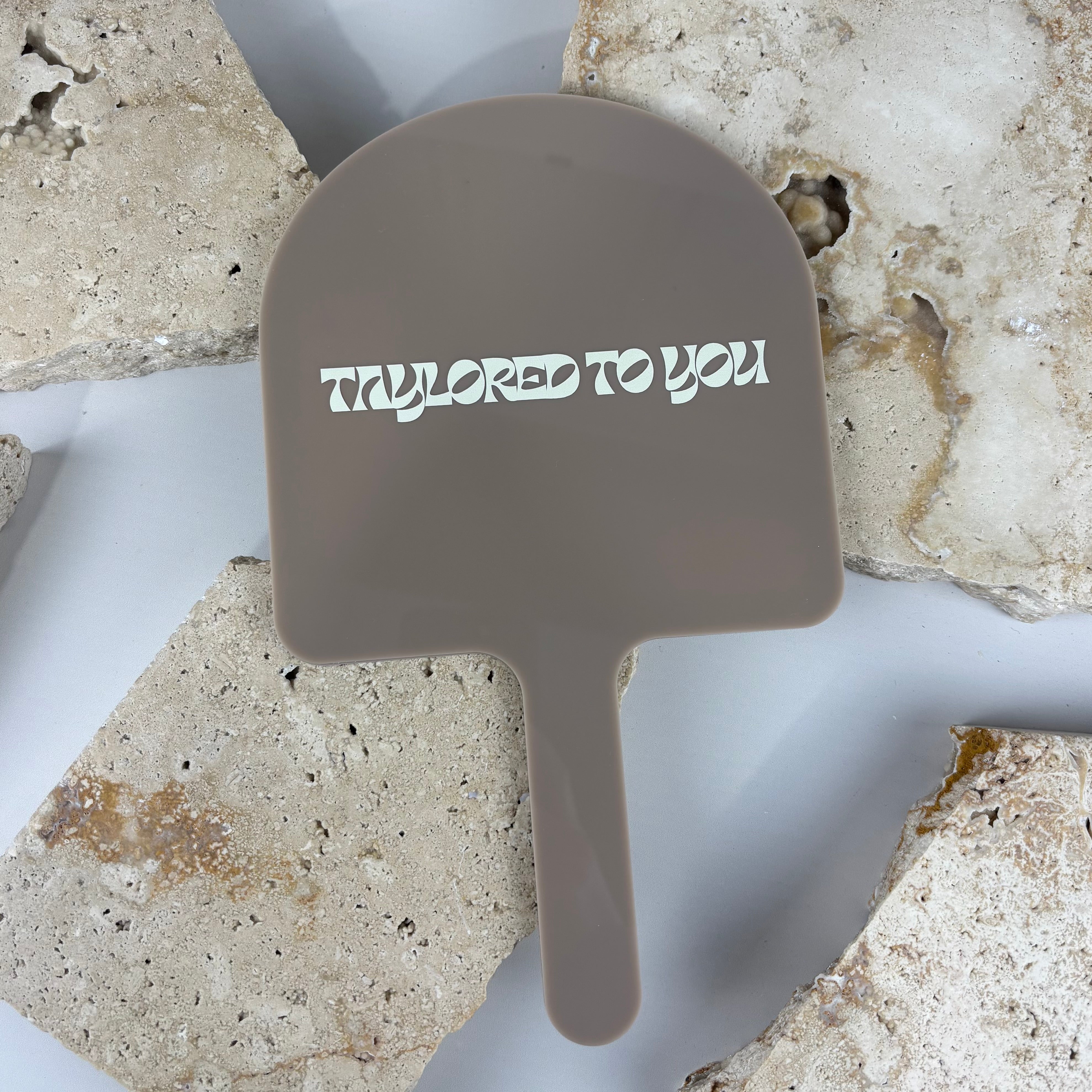 Custom acrylic handheld mirror in neutral taupe colour with white branding, personalised salon mirror for beauty business, modern handheld mirror for client photos and branding display