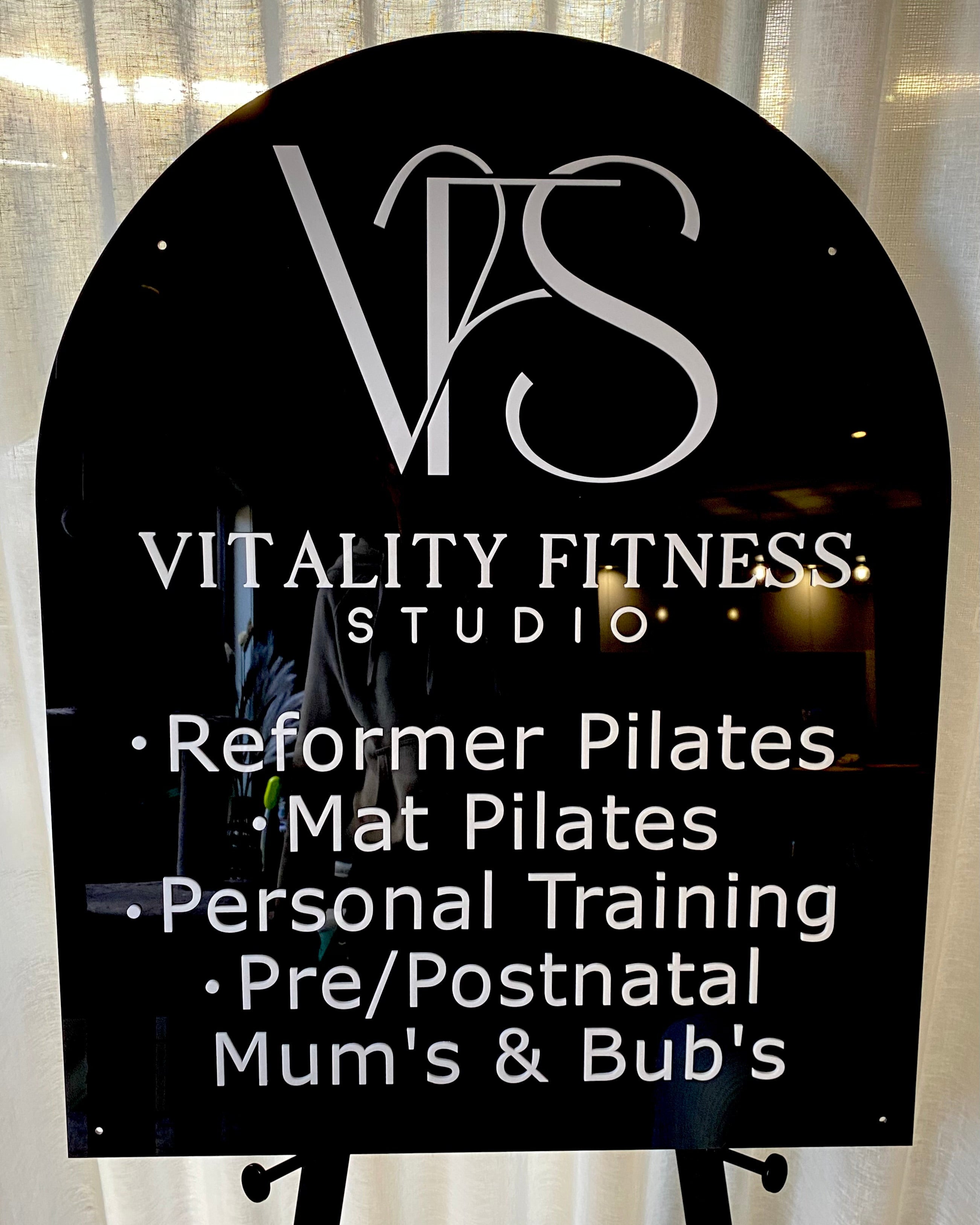 Black arch fitness studio sign with white text