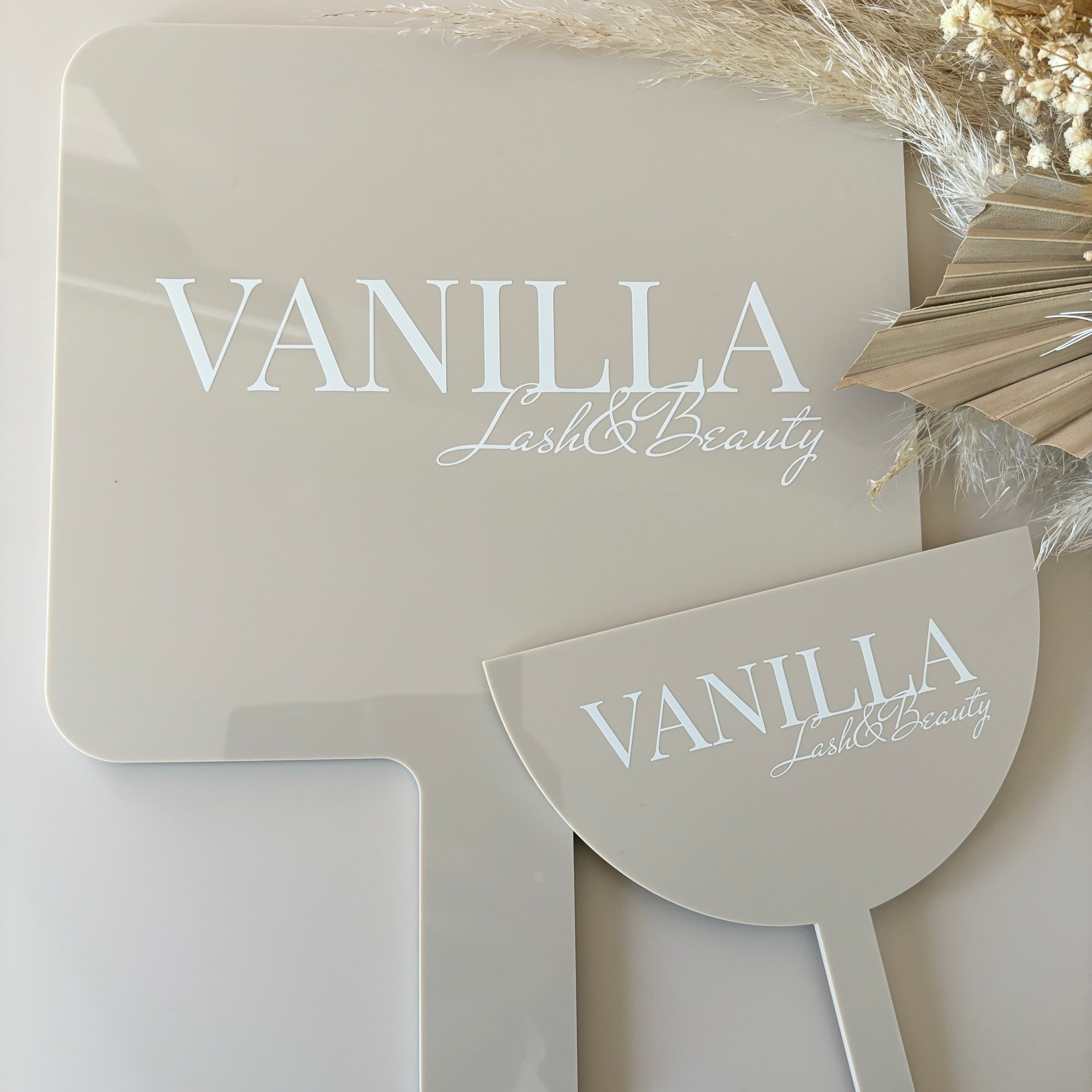 Neutral tone salon mirror and face shield engraved with Vanilla Aesthetics logo for beauty businesses