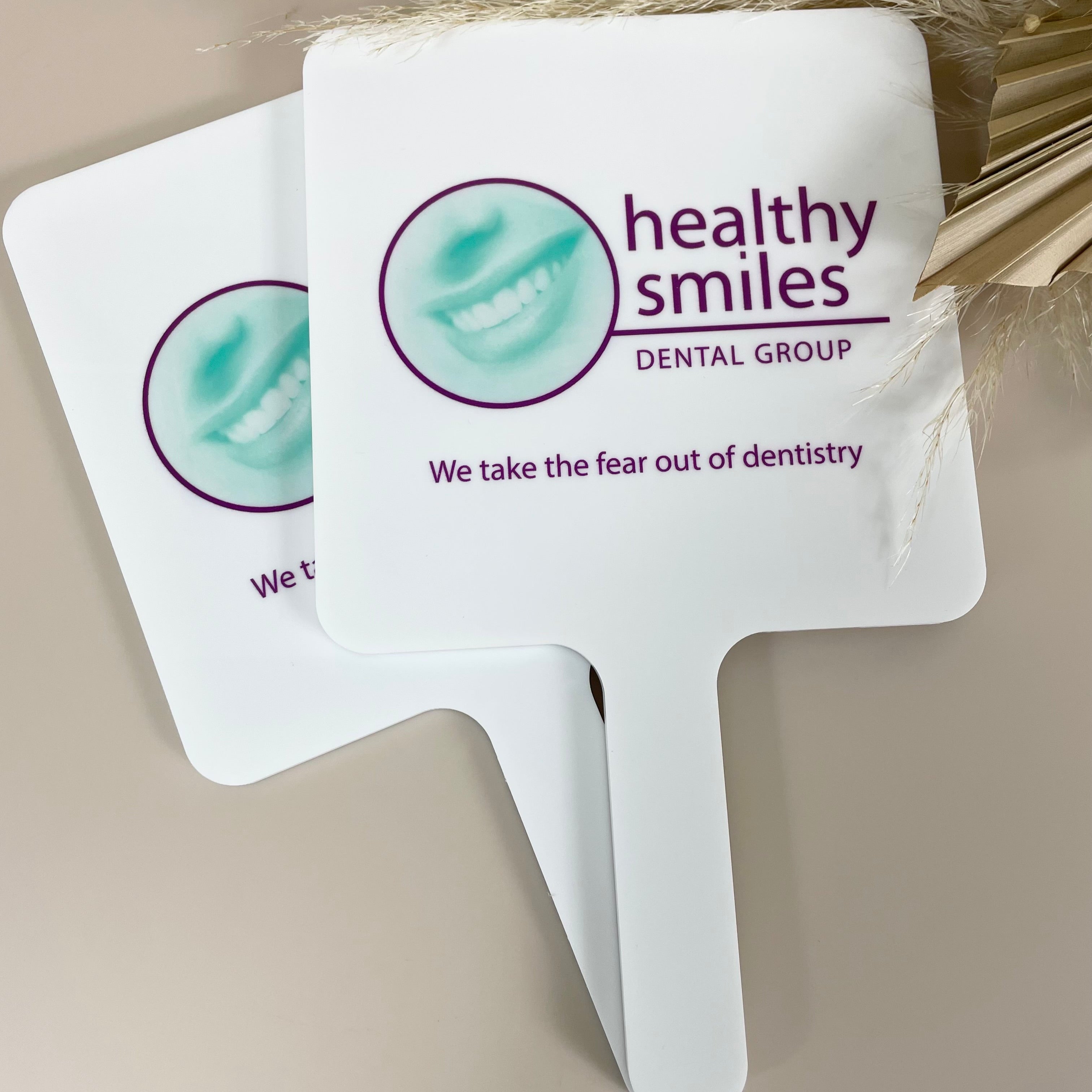 Healthy Smiles dental logo on custom handheld mirror