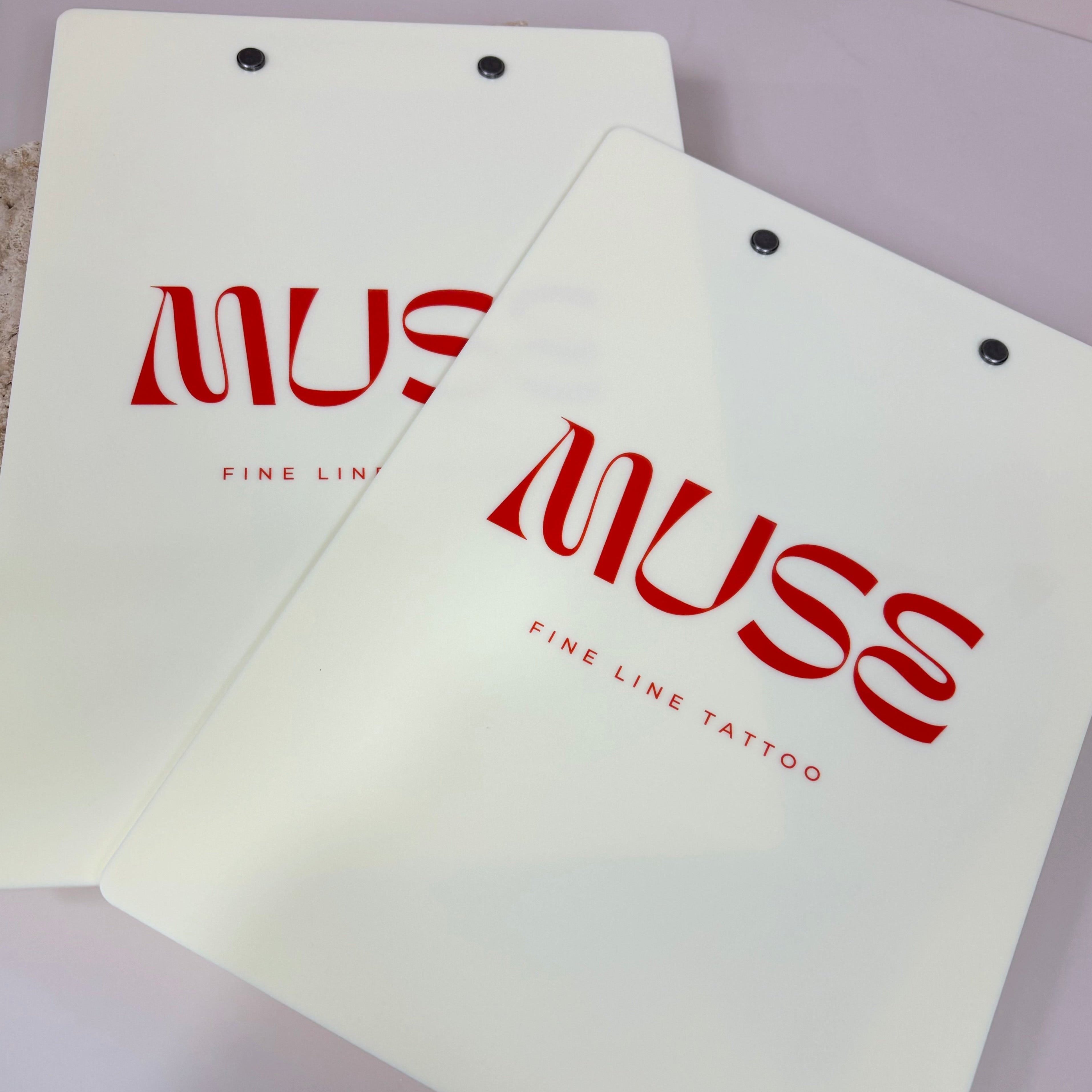 Stack of branded acrylic clipboards with logo design