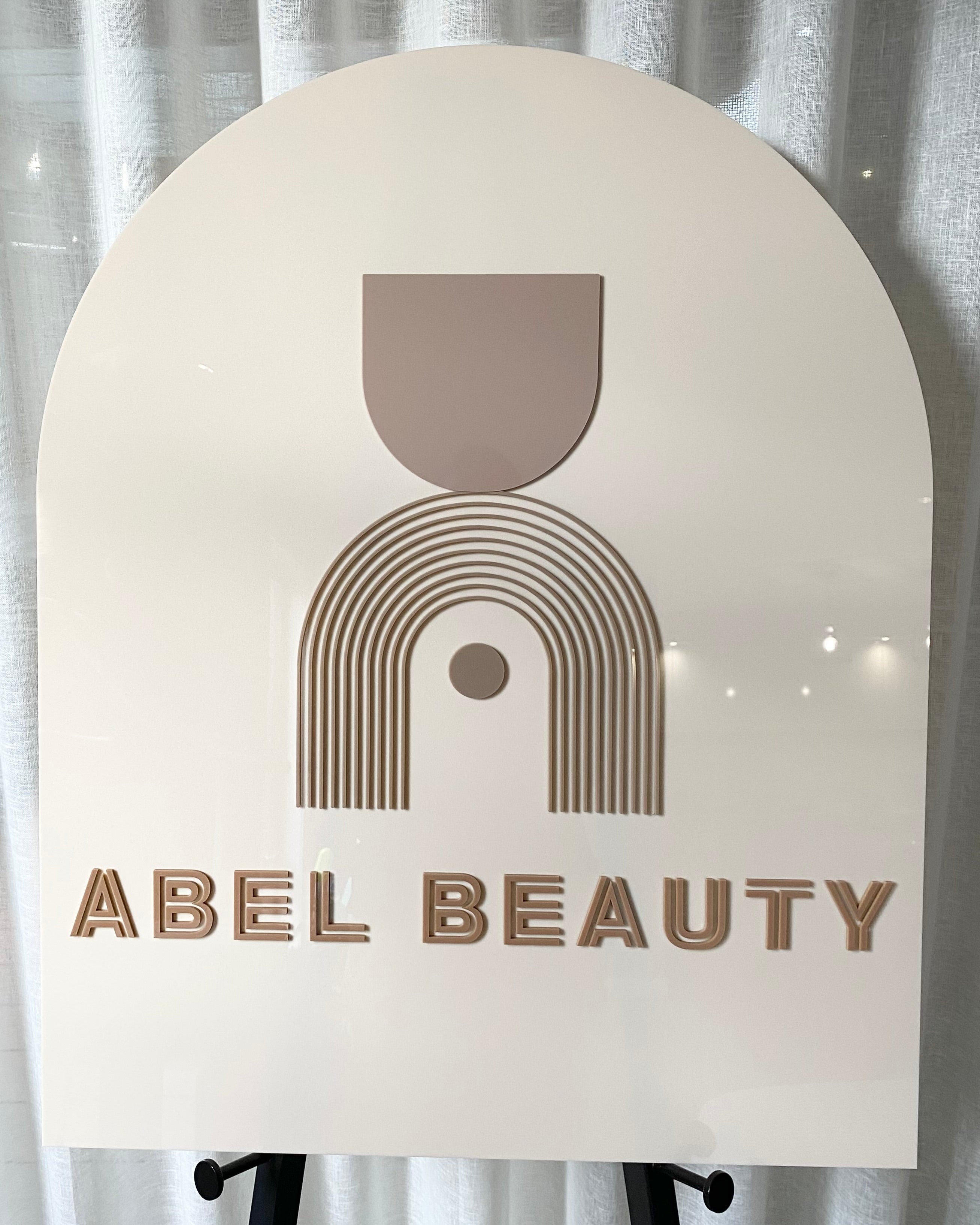 Cream arched sign with minimalist retro rainbow logo