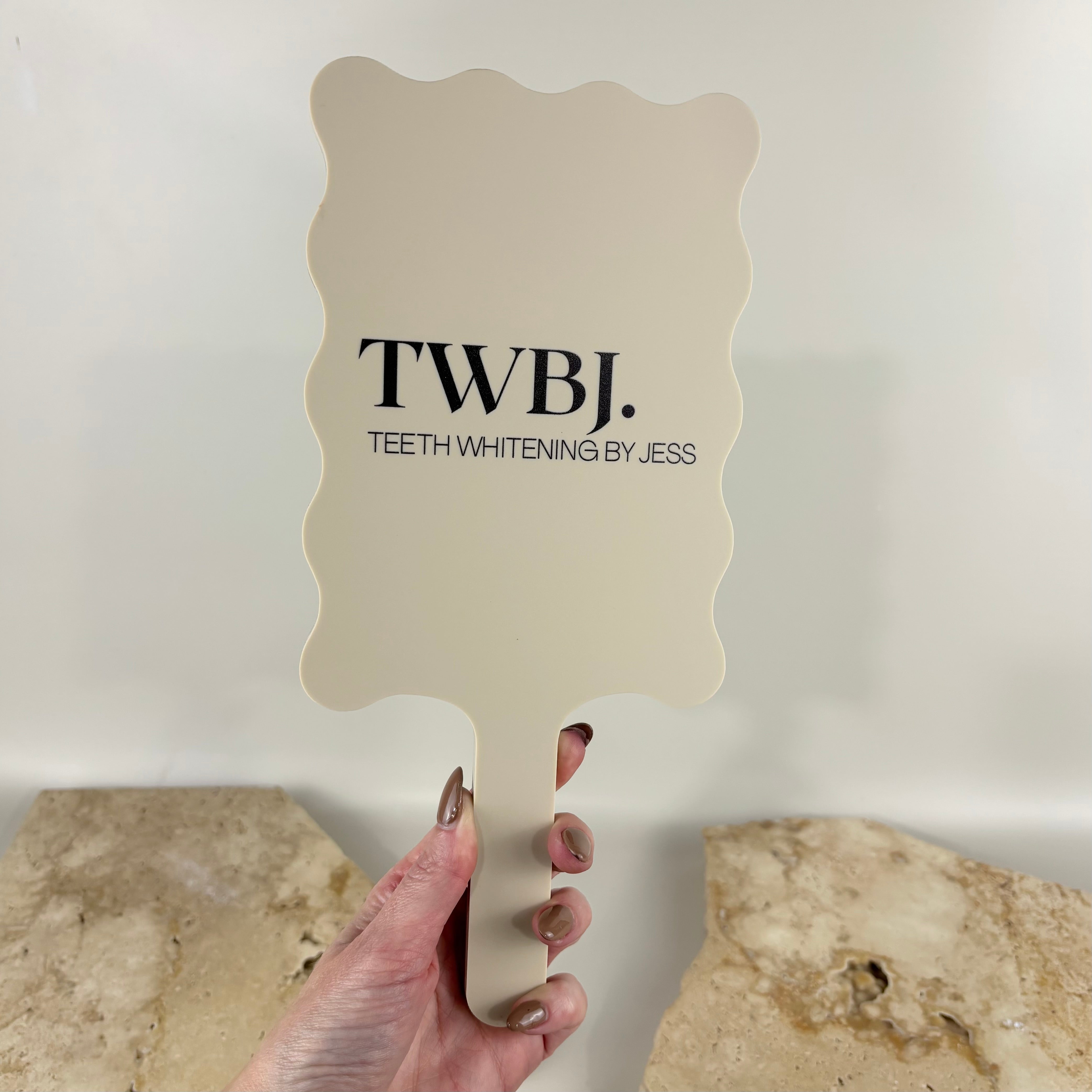 Custom acrylic handheld mirror with UV printed business logo in neutral cream finish, personalised salon mirror for teeth whitening, beauty, cosmetic and skincare businesses, perfect for client photos and branding content.