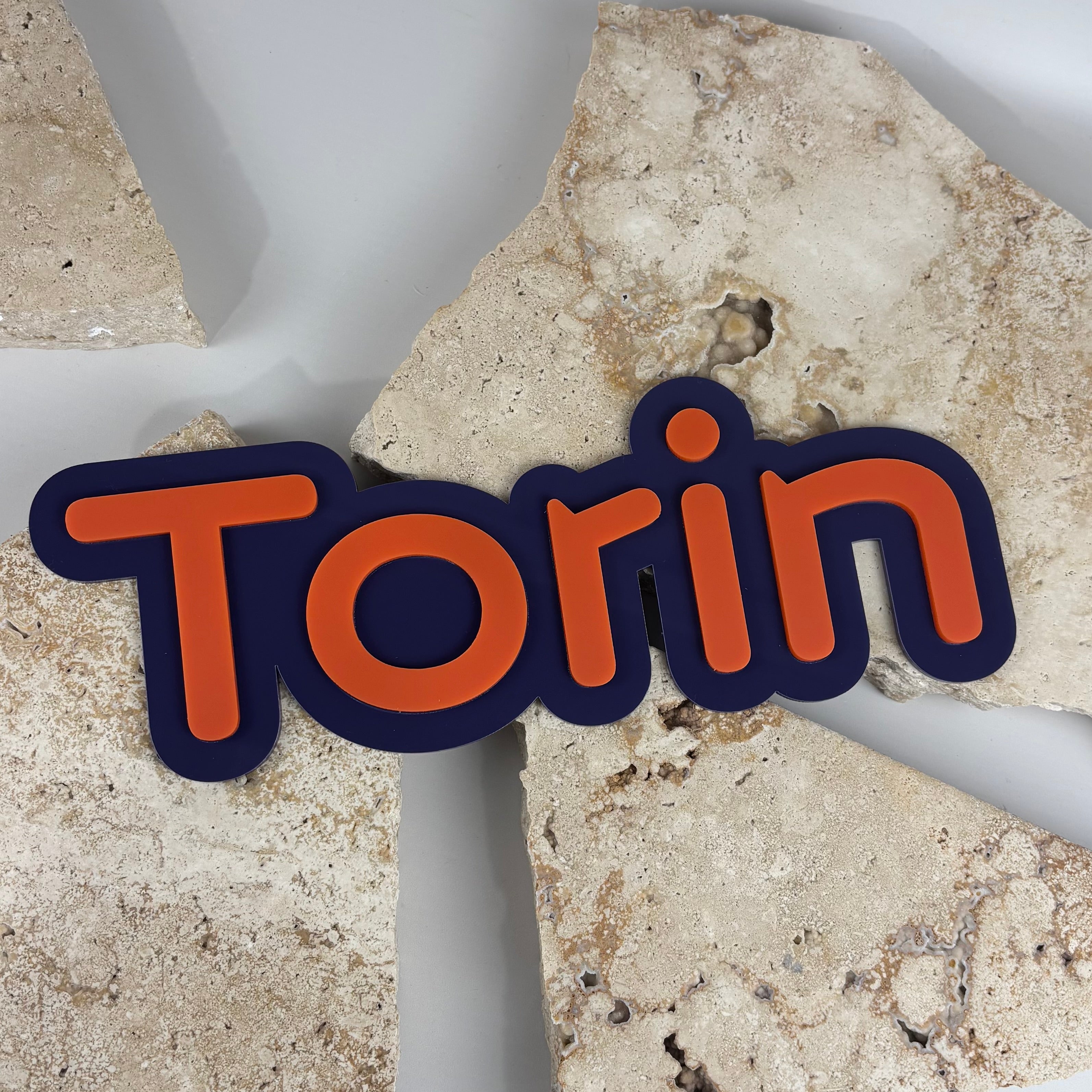 Personalised kids name sign in layered acrylic featuring bold orange raised lettering on a navy blue backing, custom children’s room decor, modern nursery name plaque, durable laser cut acrylic wall sign Australia-made