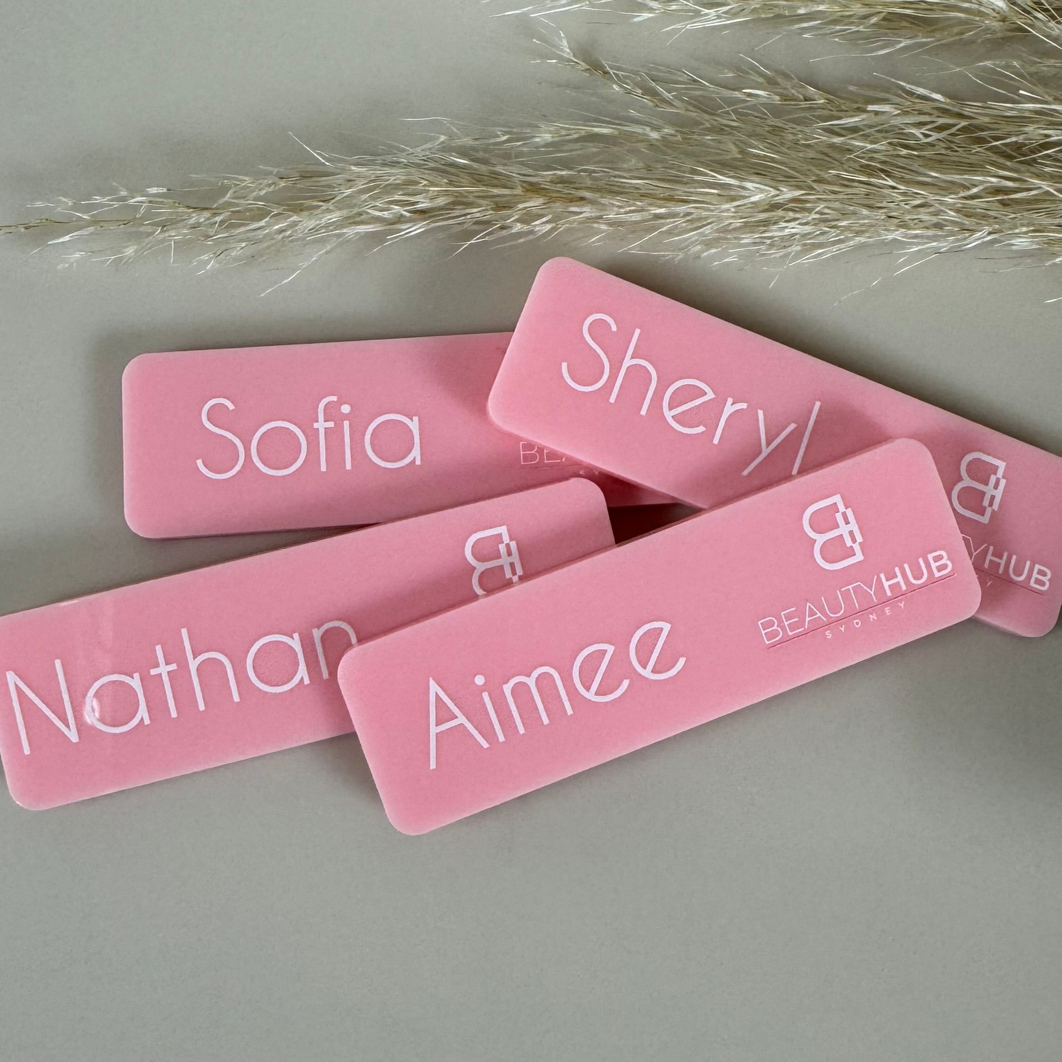 Pink printed acrylic name badges with staff names