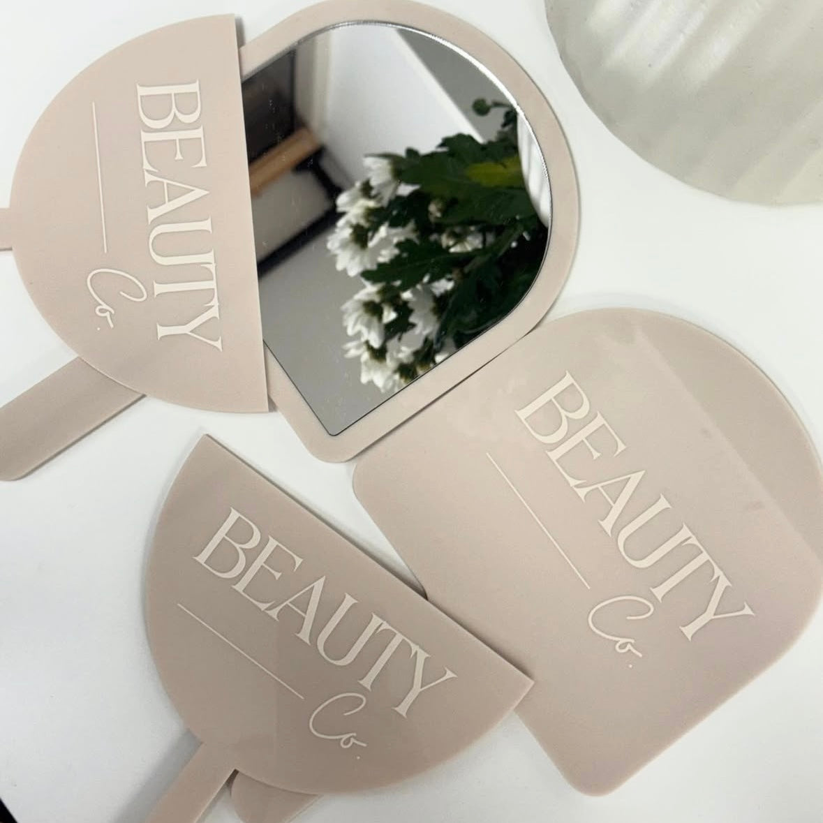 Modern beige acrylic beauty salon mirror and matching face shield with personalised white 3D lettering, custom branded handheld mirror for beauty therapists, lash techs, makeup artists and salon businesses in Australia and New Zealand