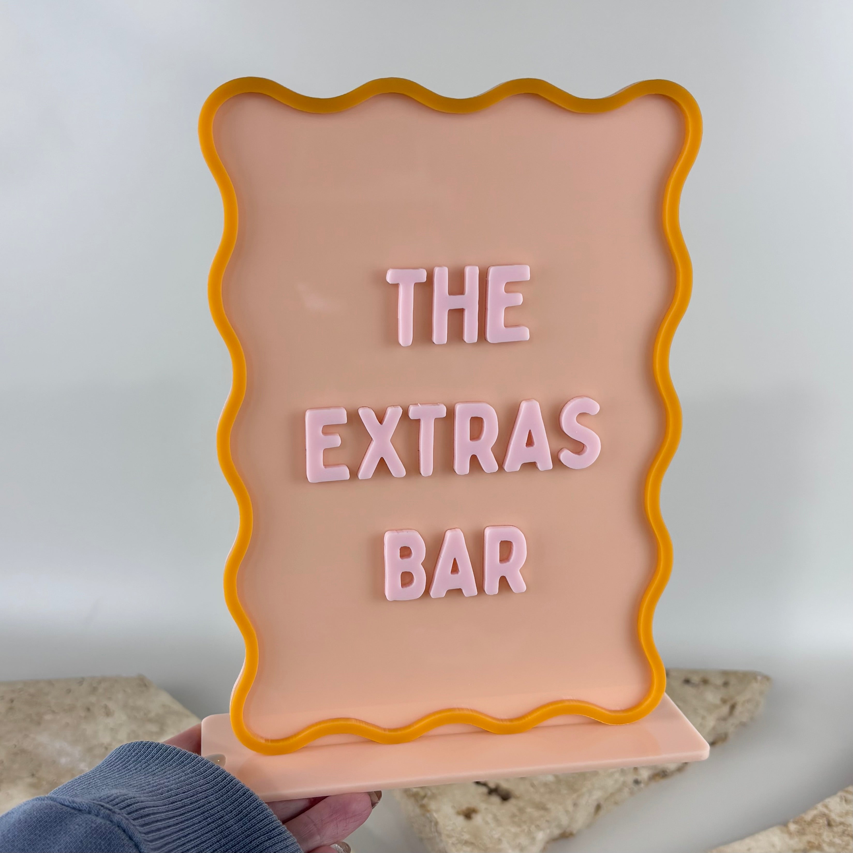 Pastel pink scallop display stand with interchangeable 3D letters for pricing, menus, promotions and countertop business displays in retail stores, cafés, salons and events.