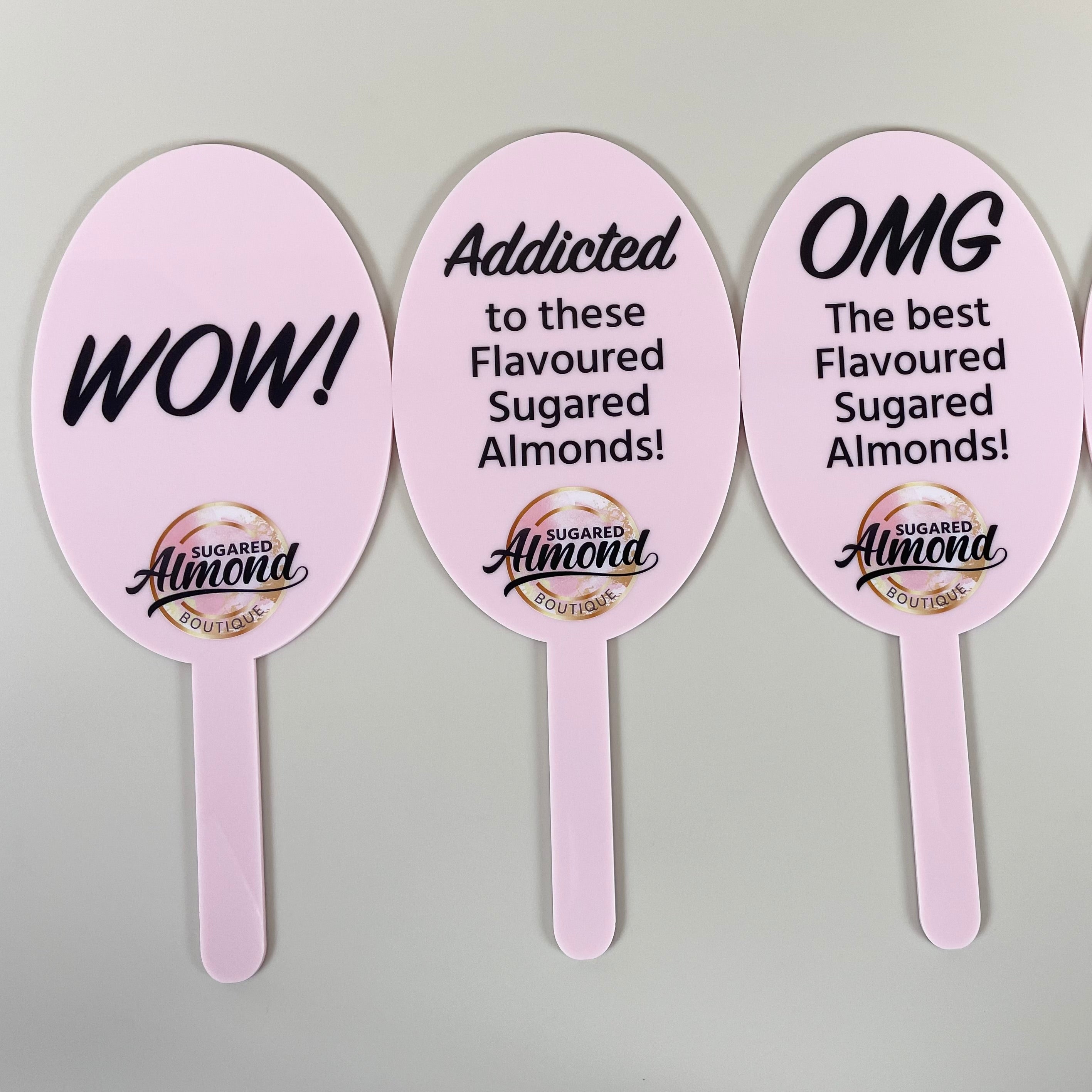 Set of pink custom prop paddles with printed event slogans and logos