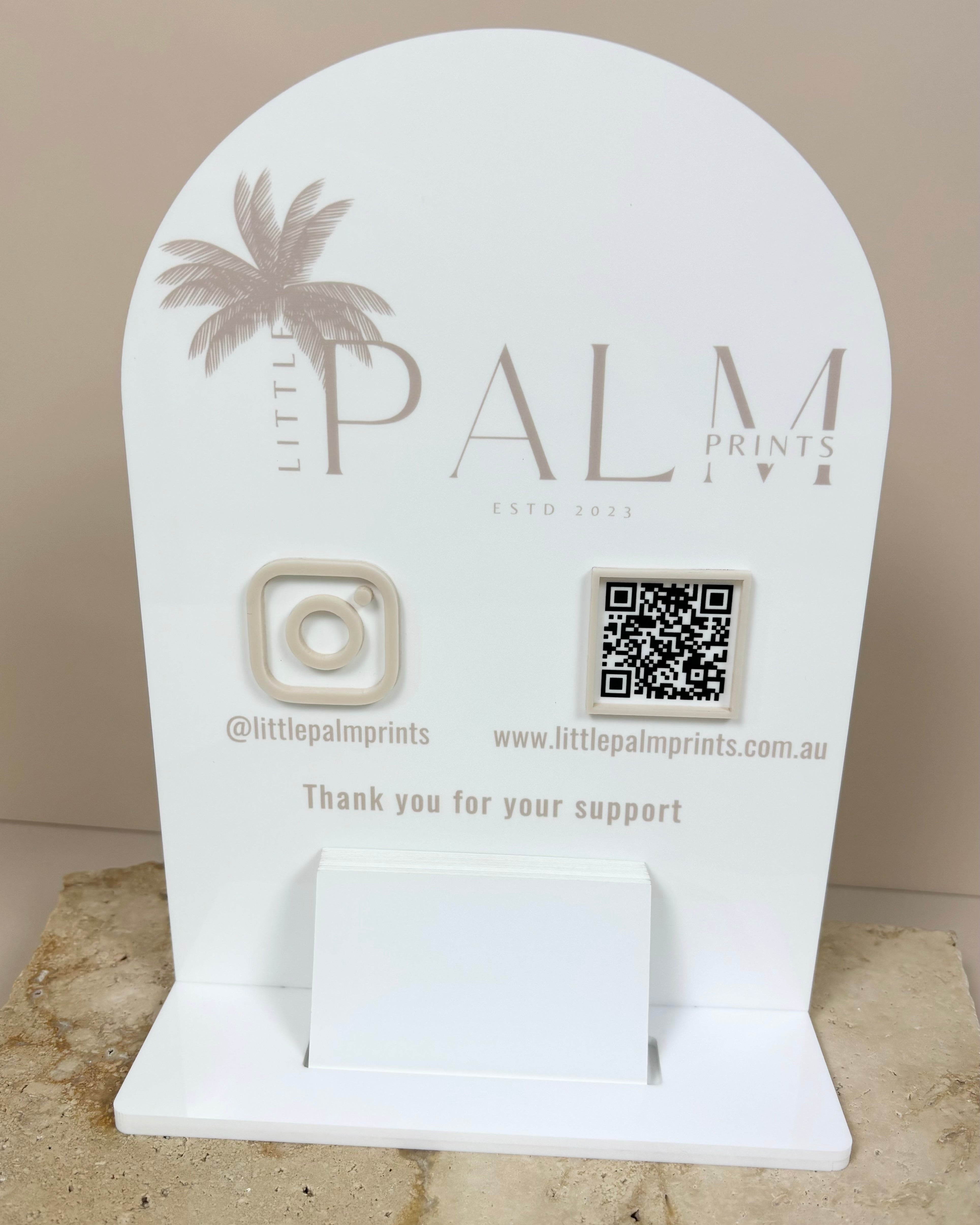 White Palm-branded counter card holder with gold logo and QR code