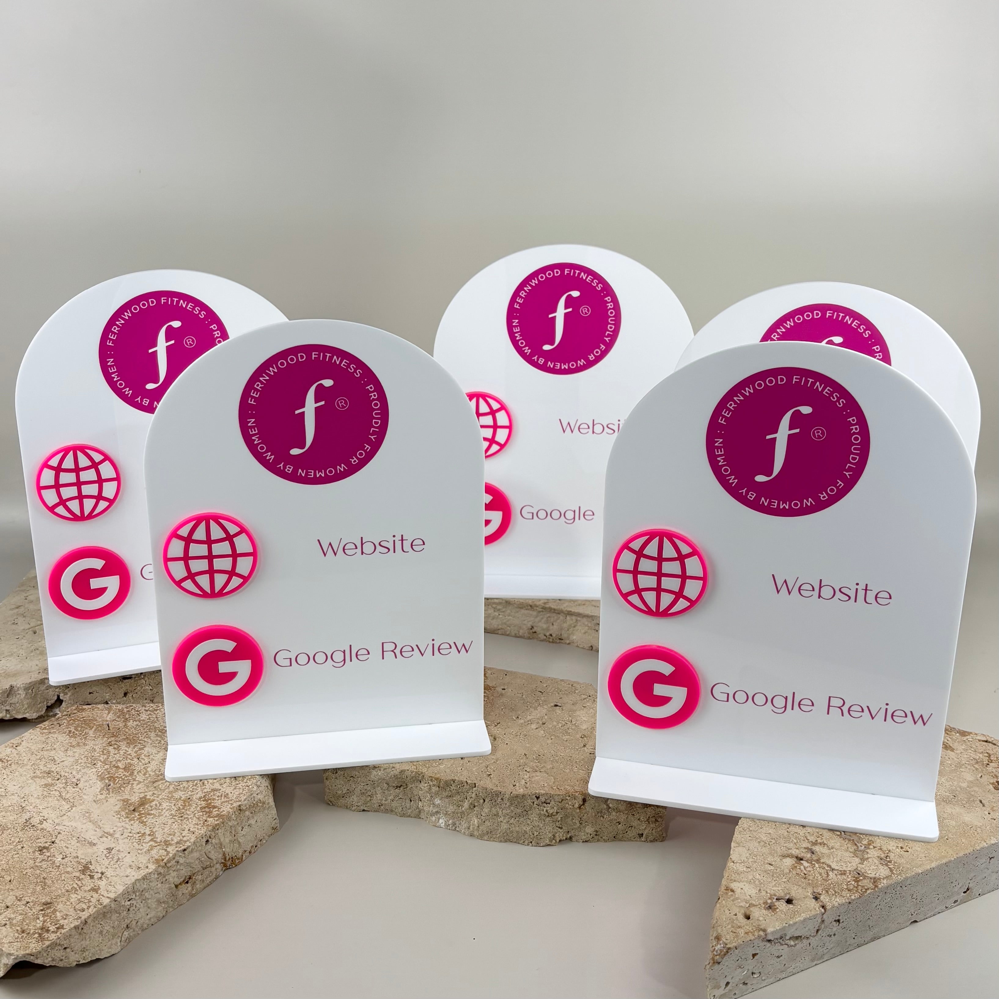 Custom white acrylic Google review and website stands with Fernwood Fitness branding, pink UV print and raised 3D acrylic icons.
