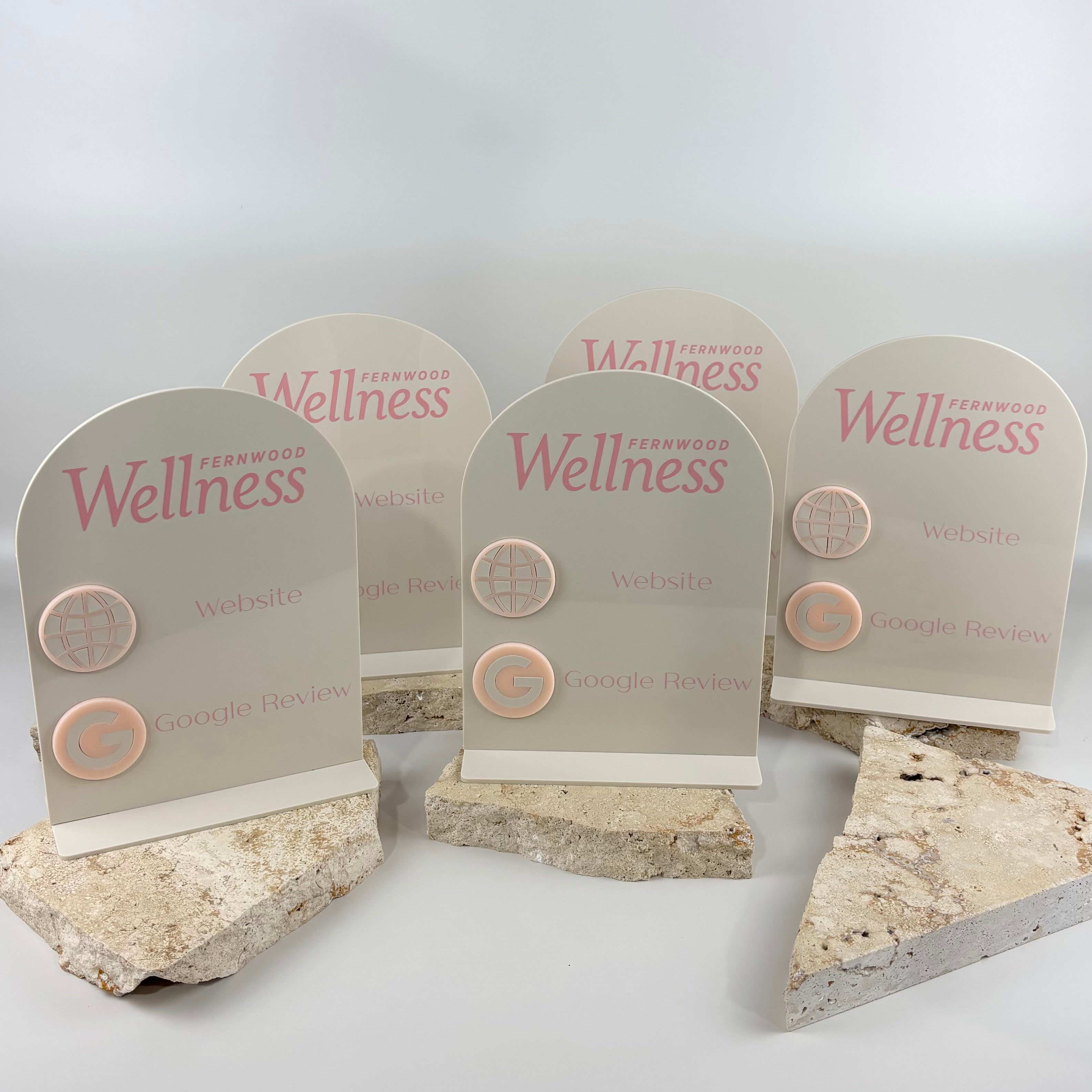 Custom white acrylic Google review and website stands with Fernwood Wellness branding, soft pink UV print and raised 3D acrylic icons.